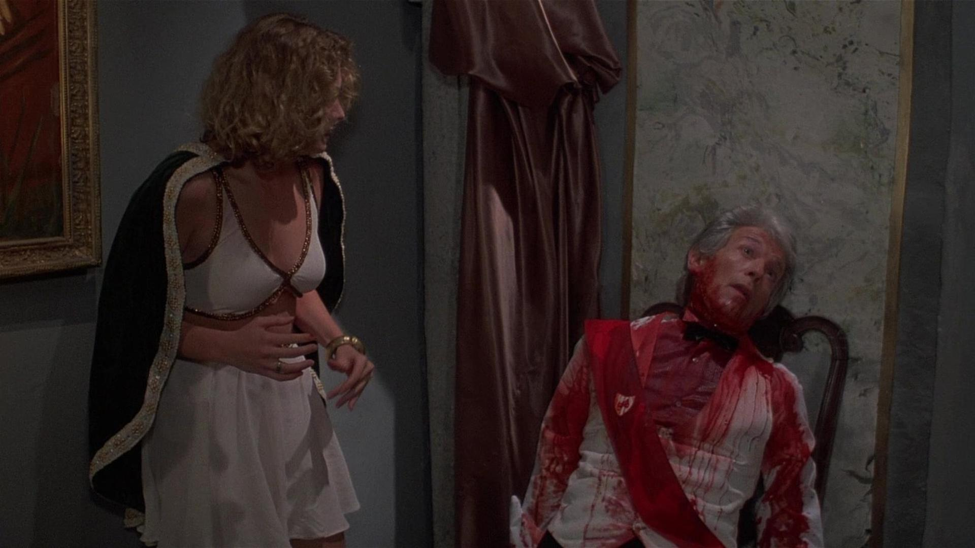 Eine Frau in einem weißen Kleid und Umhang blickt auf einen blutüberströmten Mann.