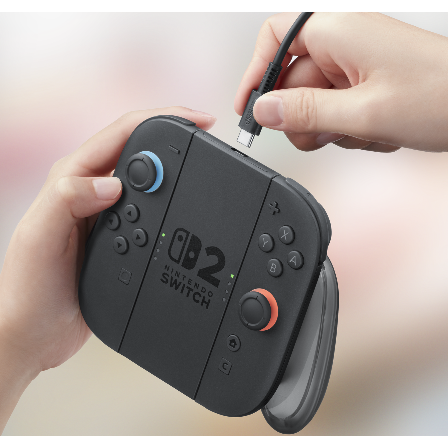 Handen sluiten een zwarte Nintendo Switch Joy-Con gripkabel aan.