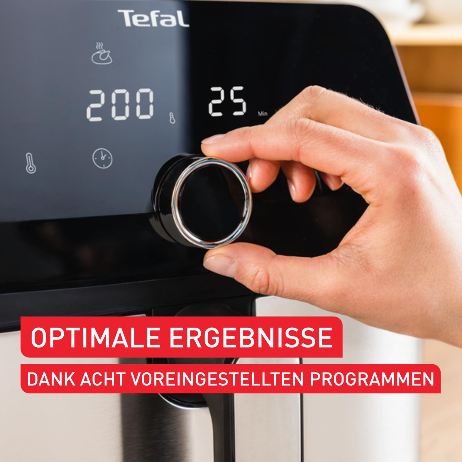 Eine Hand dreht einen Knopf an einem Tefal Heißluftfritteuse-Display.