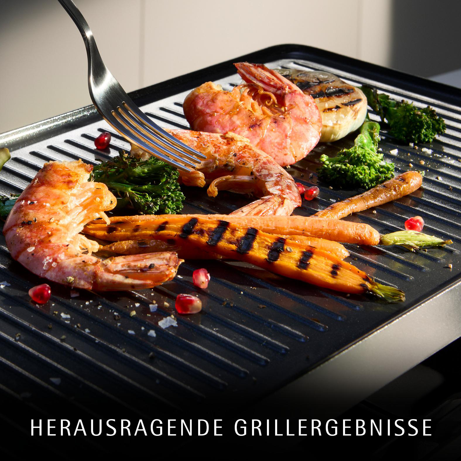 Gegrillte Garnelen und Karotten mit Brokkoli und Granatapfelkernen auf einem Grill.