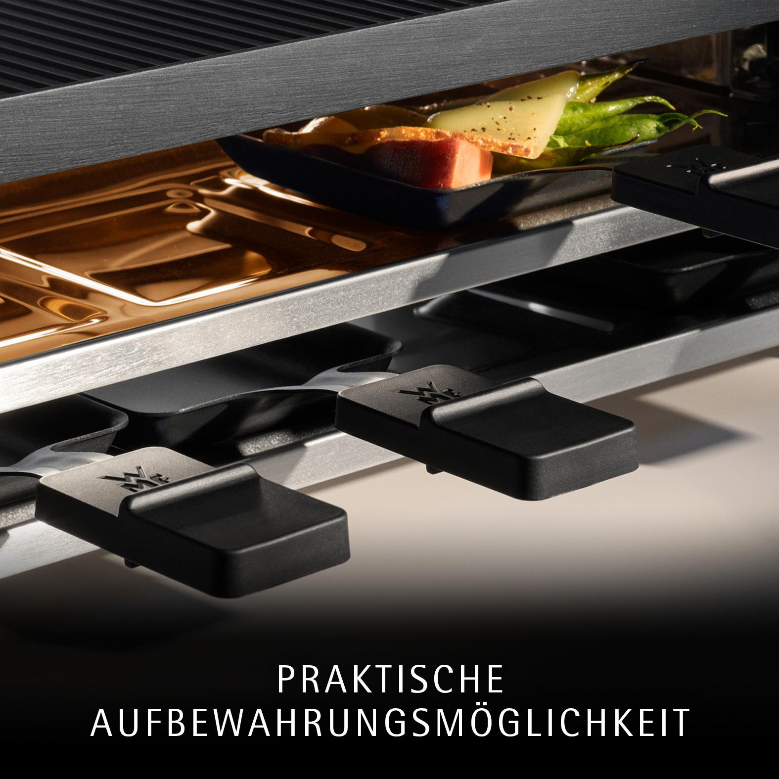 Nahaufnahme eines Raclette-Grills mit Pfännchen und Käse.