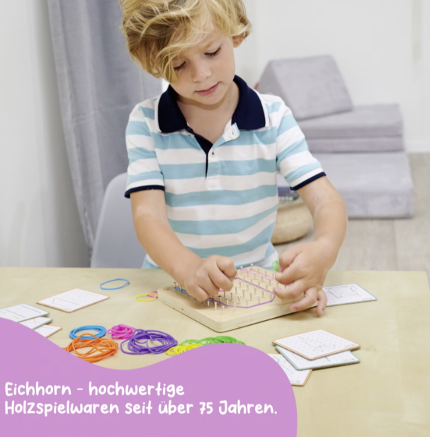 Ein kleiner Junge mit blonden Haaren spielt mit einem Holzbrett und bunten Gummibändern.