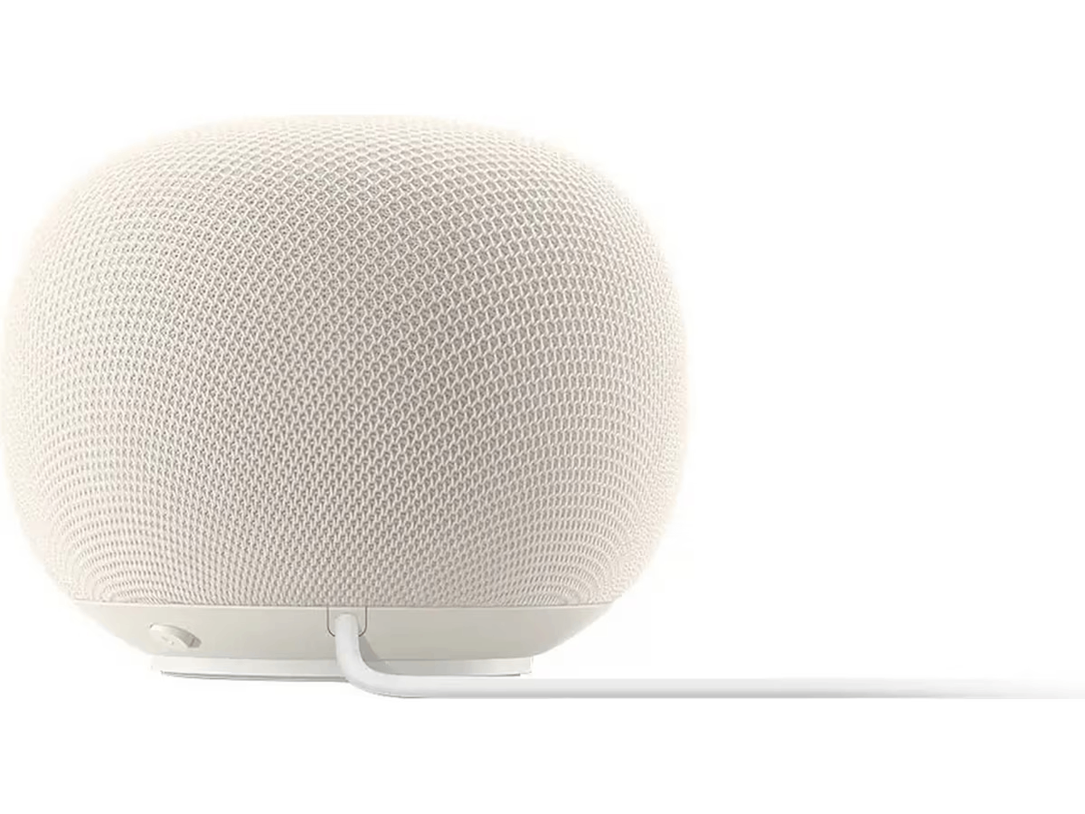 Altavoz inteligente beige claro cubierto de tela con cable blanco.