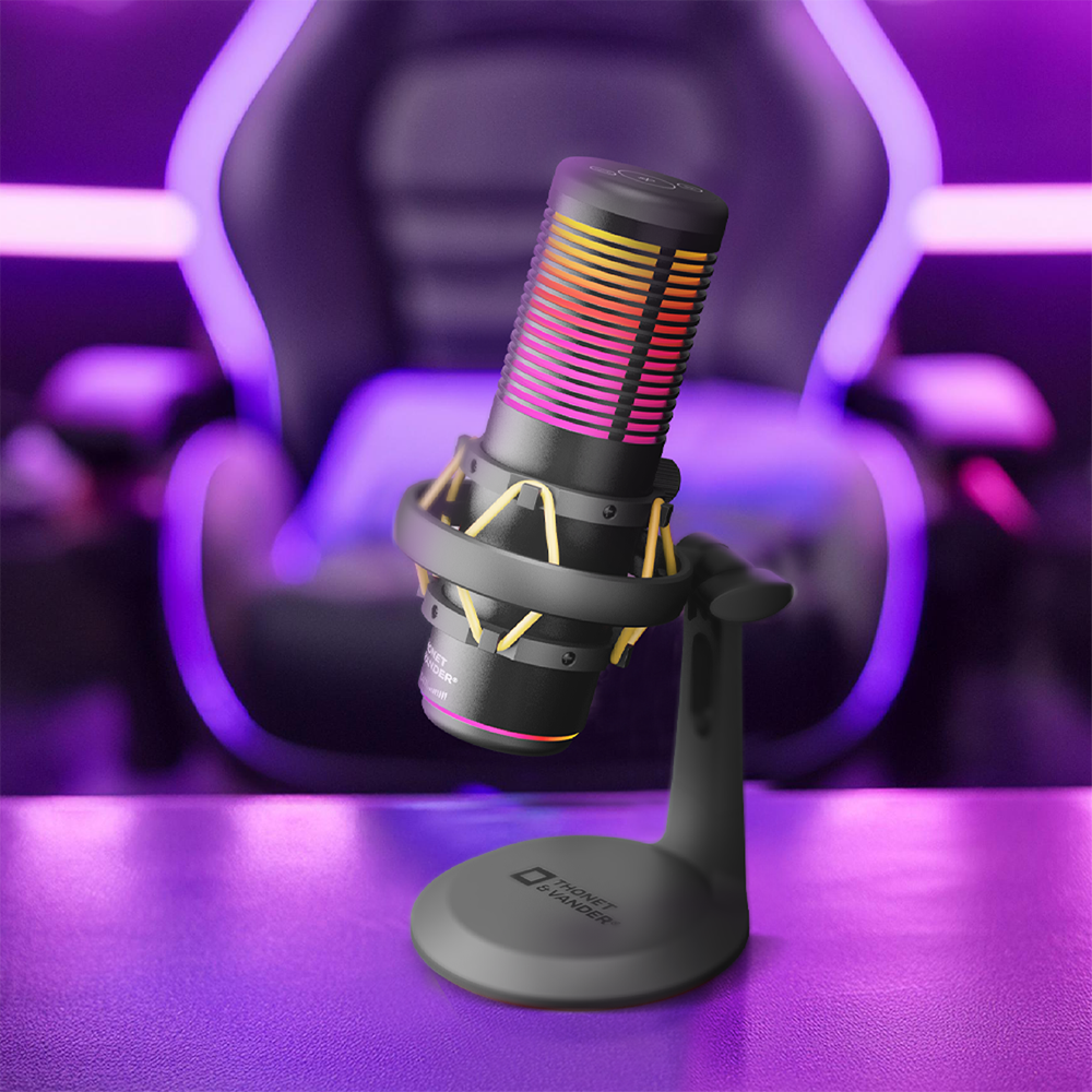 Egy RGB világítású fekete mikrofon áll egy állványon egy gamer szék előtt.