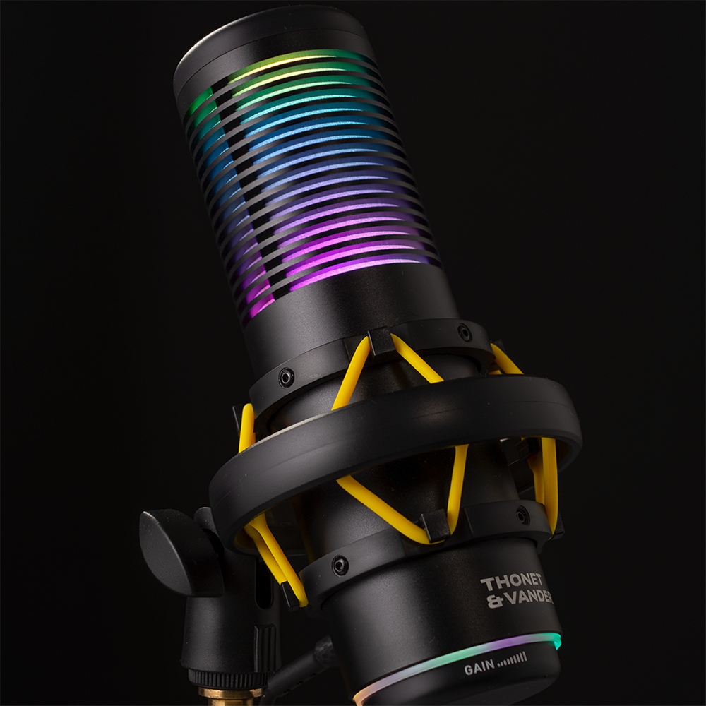Egy fekete mikrofon RGB világítással és sárga díszítéssel fekete háttéren.