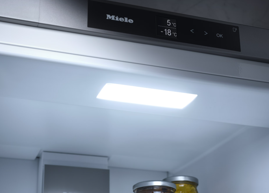 Innenansicht eines Kühlschranks mit Miele-Logo, Display und LED-Beleuchtung.