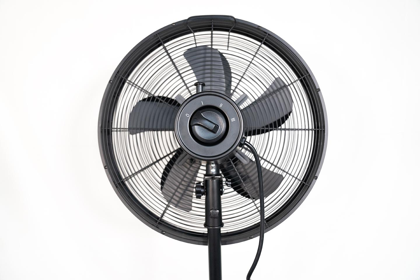 Ein schwarzer Standventilator mit drei Flügeln und einem runden Gitter.
