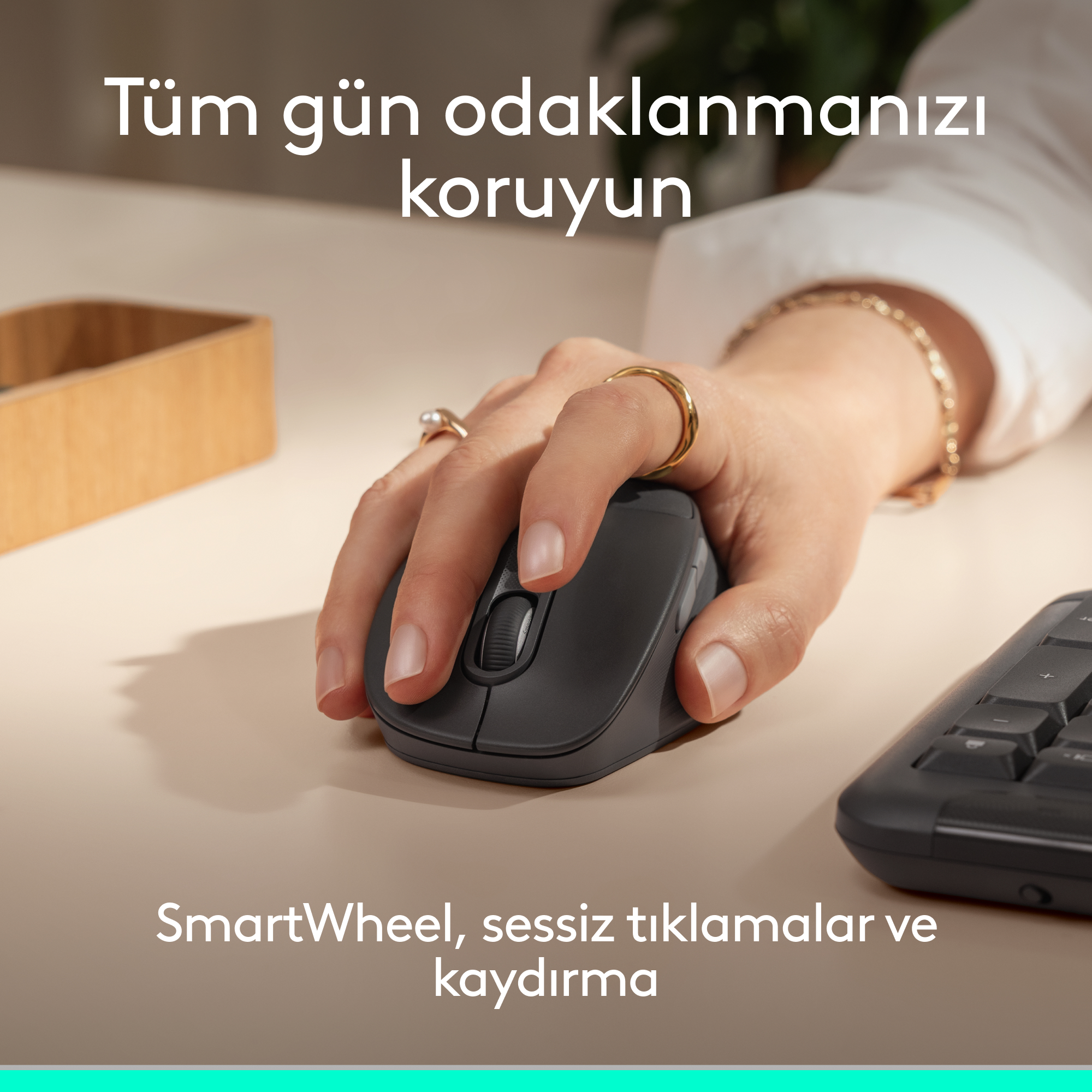 Bir el, klavyenin yanında açık renkli bir masada koyu renkli bilgisayar faresi kullanıyor.