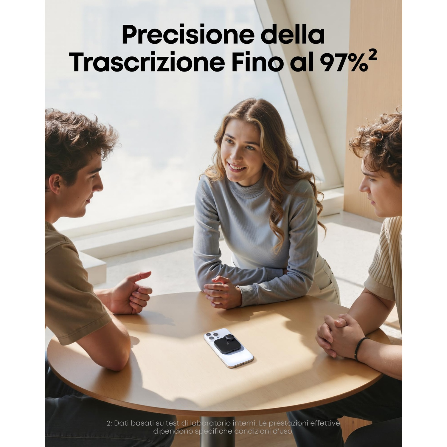 Tre giovani seduti a un tavolo di legno. Uno smartphone è sul tavolo.