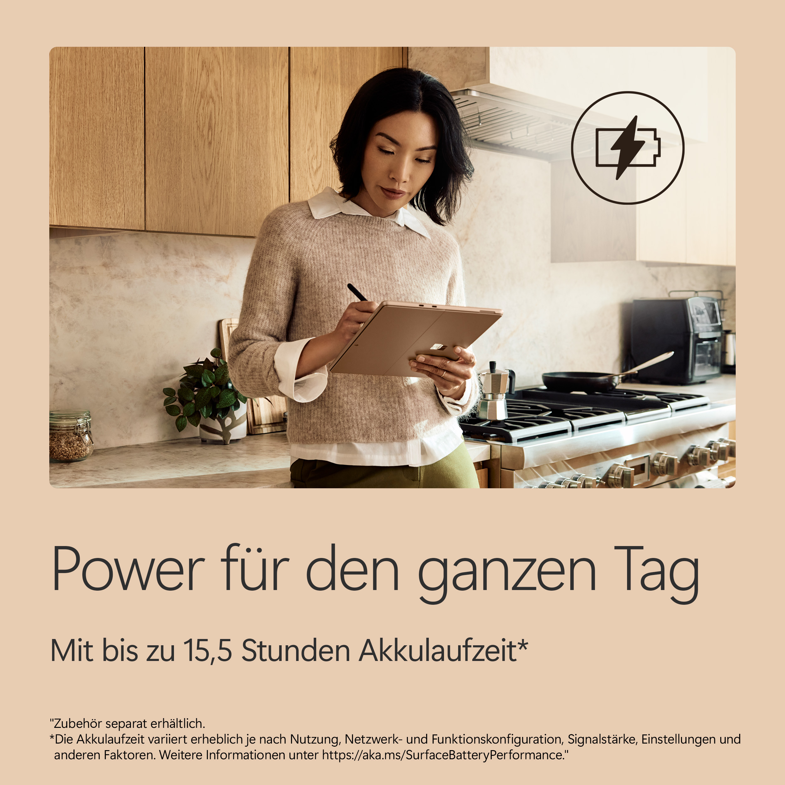 Frau in Küche mit Tablet, Akkusymbol über dem Herd.
