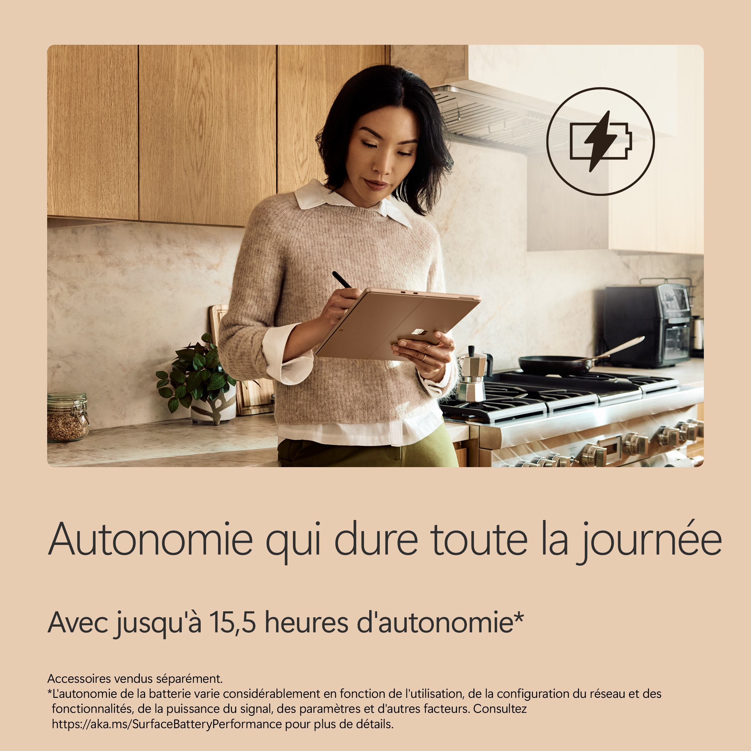 Une femme avec une tablette dans une cuisine, avec une icône de batterie.