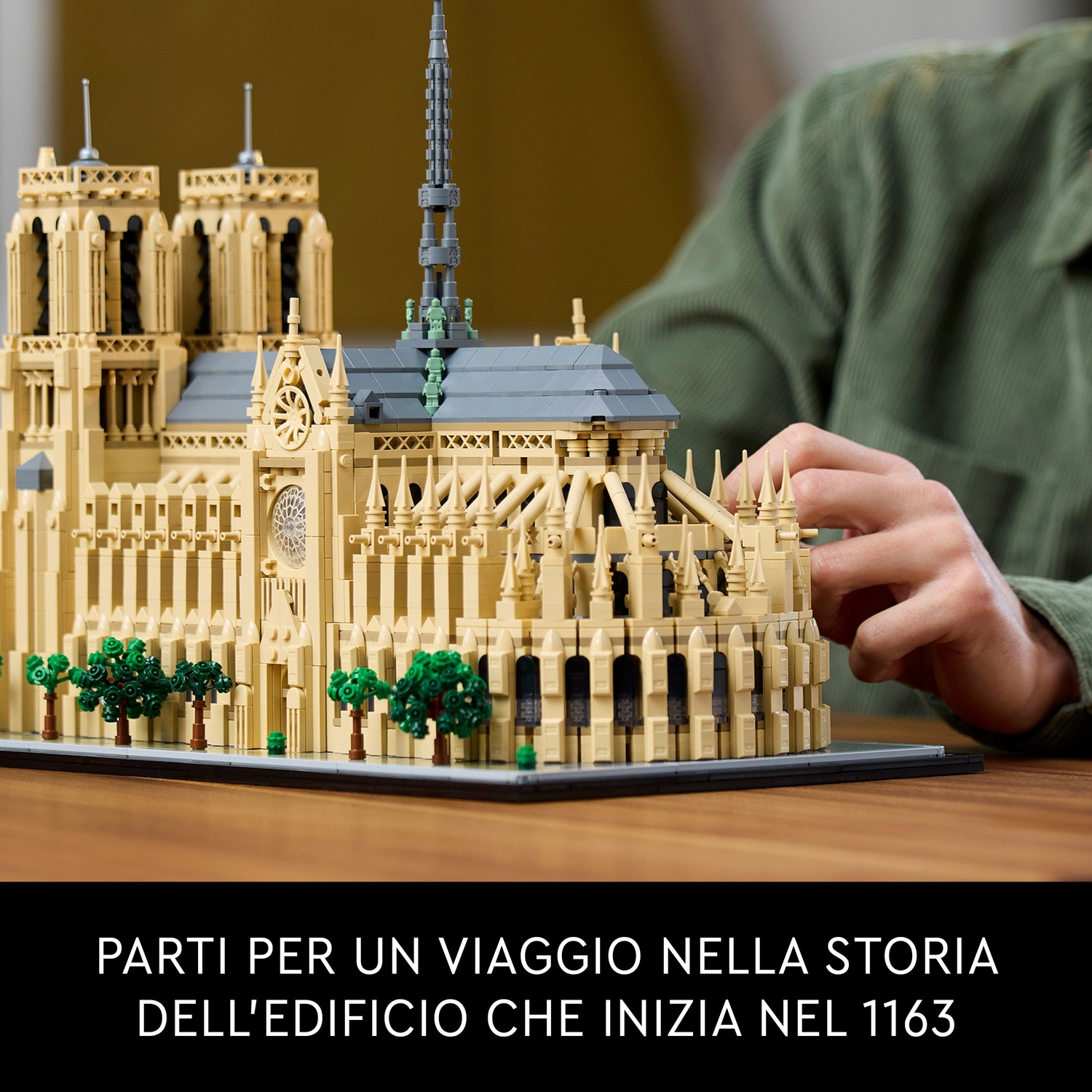 Dettagliato modello LEGO della Cattedrale di Notre-Dame con alberi e una persona sullo sfondo.