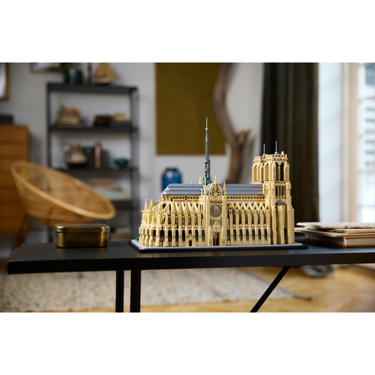 Un modello Lego di Notre Dame è su un tavolo nero con libri.