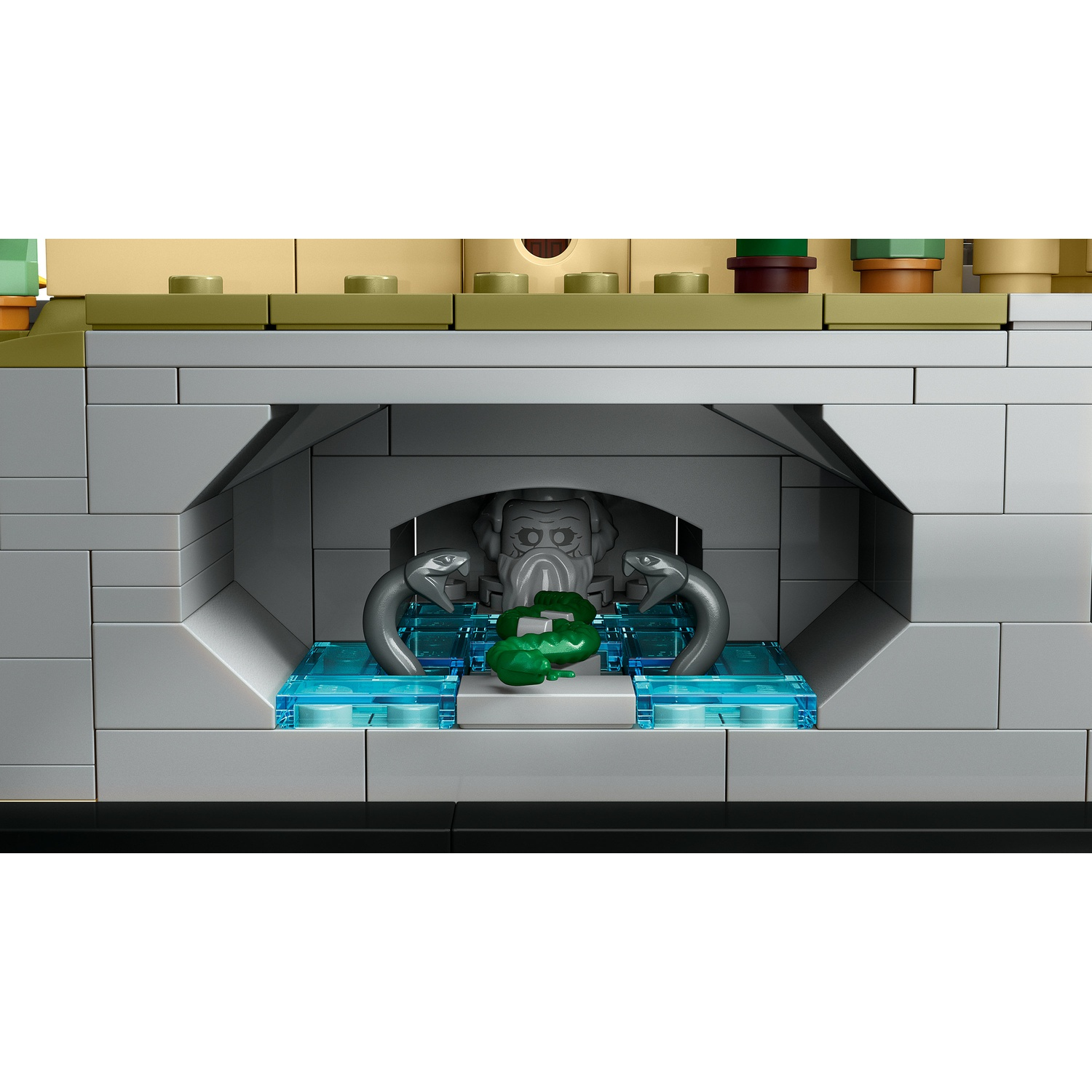 Una scultura Lego di un volto grigio con serpenti e un oggetto verde su acqua blu.