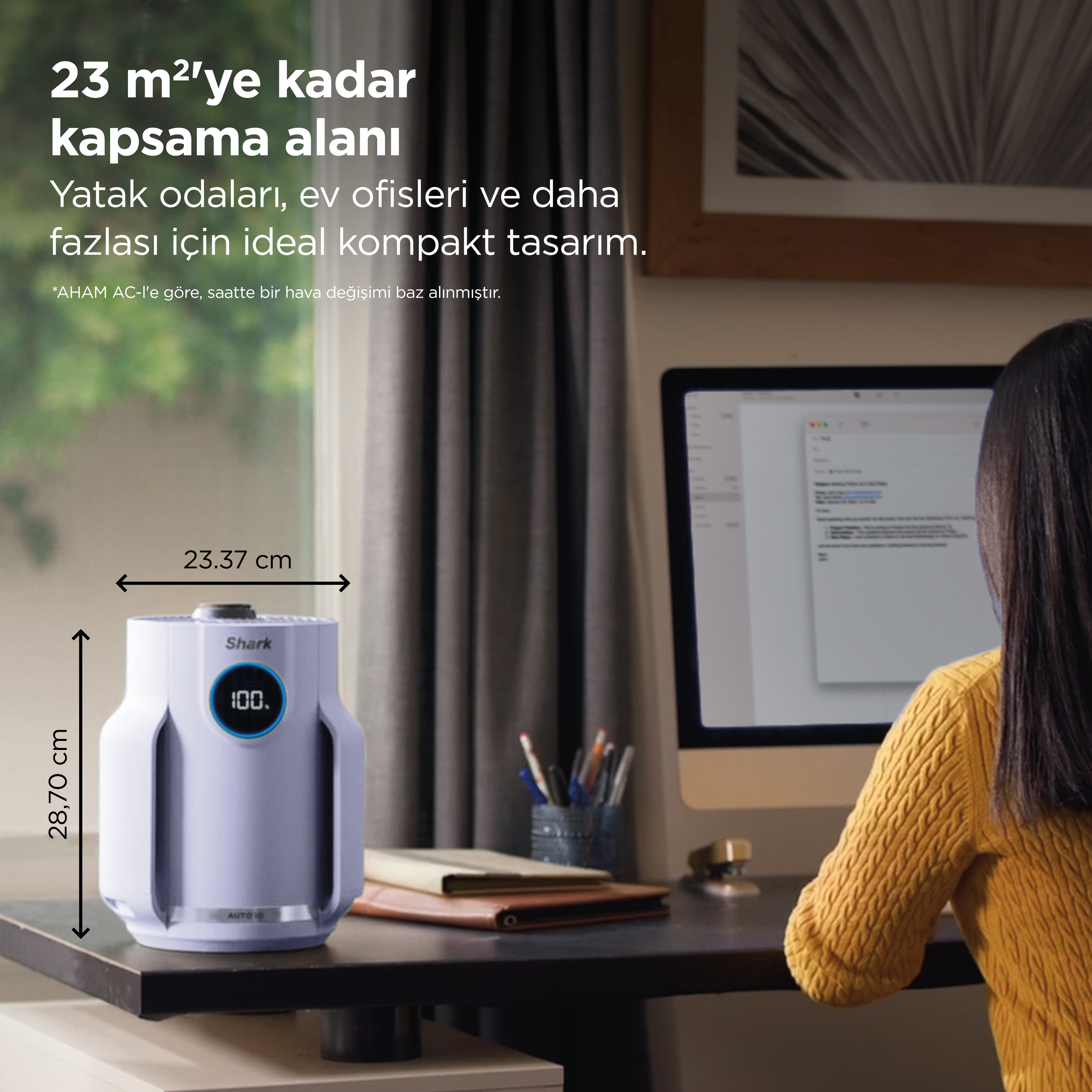 Beyaz bir hava temizleyici, bilgisayarın yanında masada duruyor. Boyutlar gösteriliyor.