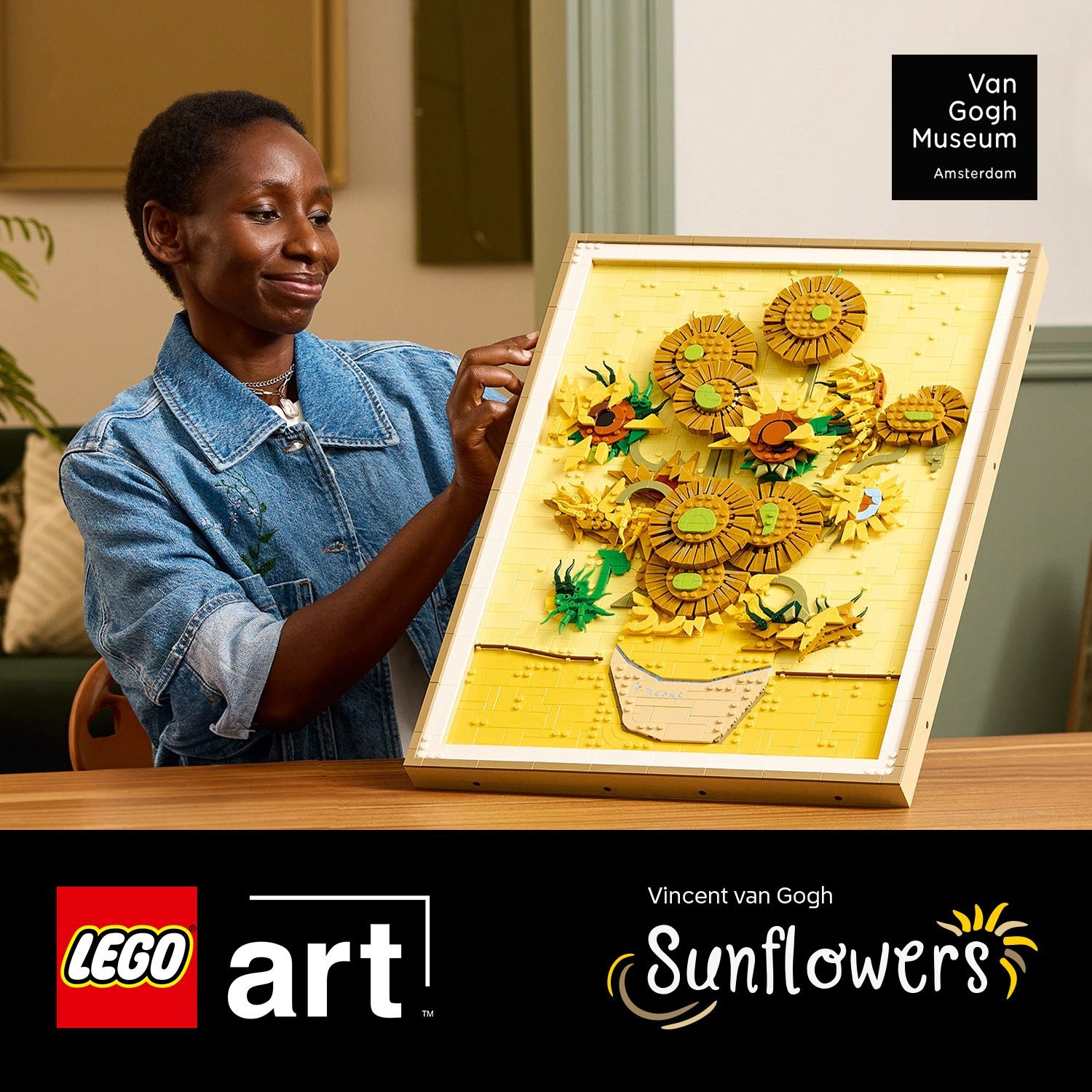 Una donna tiene un mosaico Lego dei Girasoli di Van Gogh. Giallo, arancione, marrone.