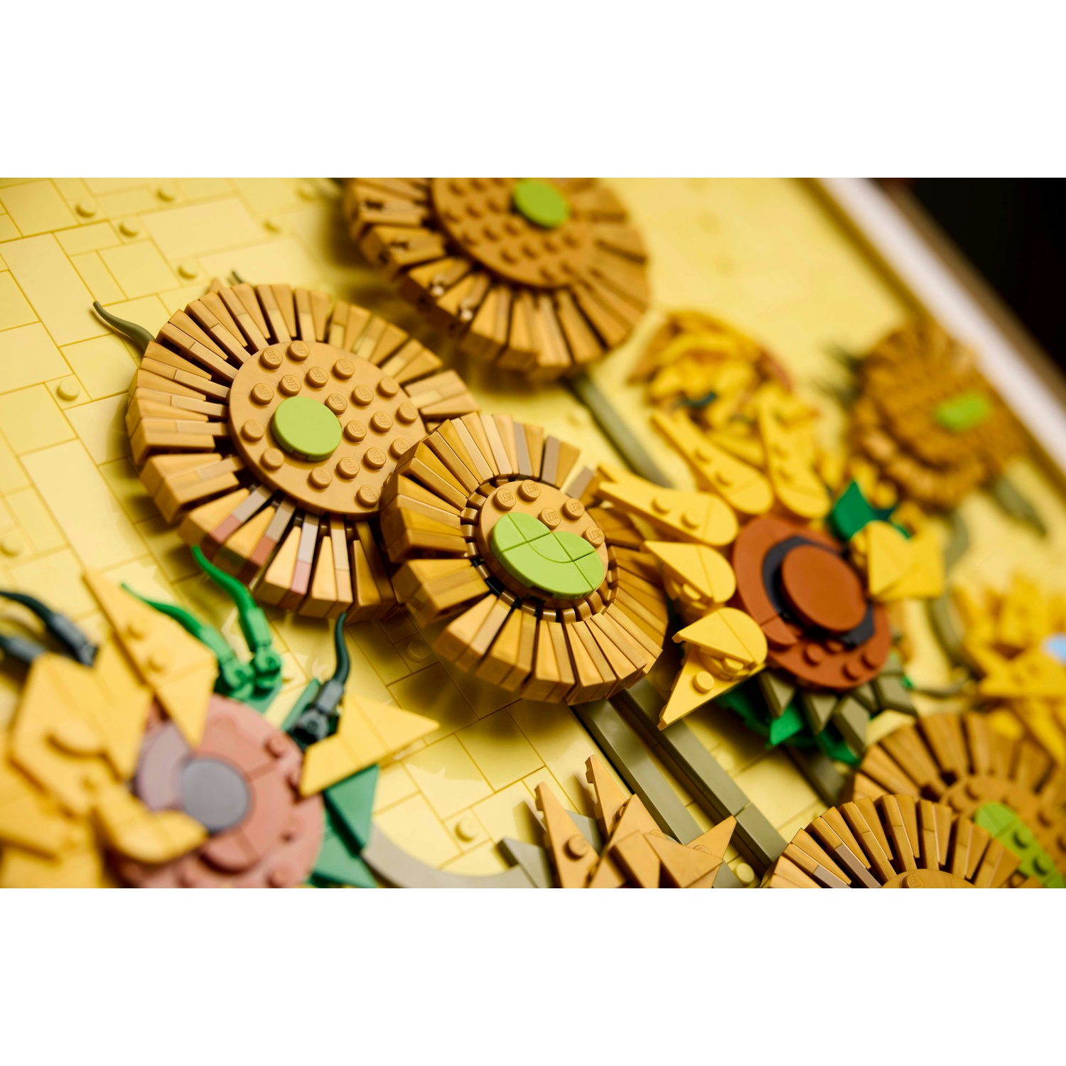 Girasoli in mattoncini Lego con centri marroni e accenti verdi su sfondo giallo.