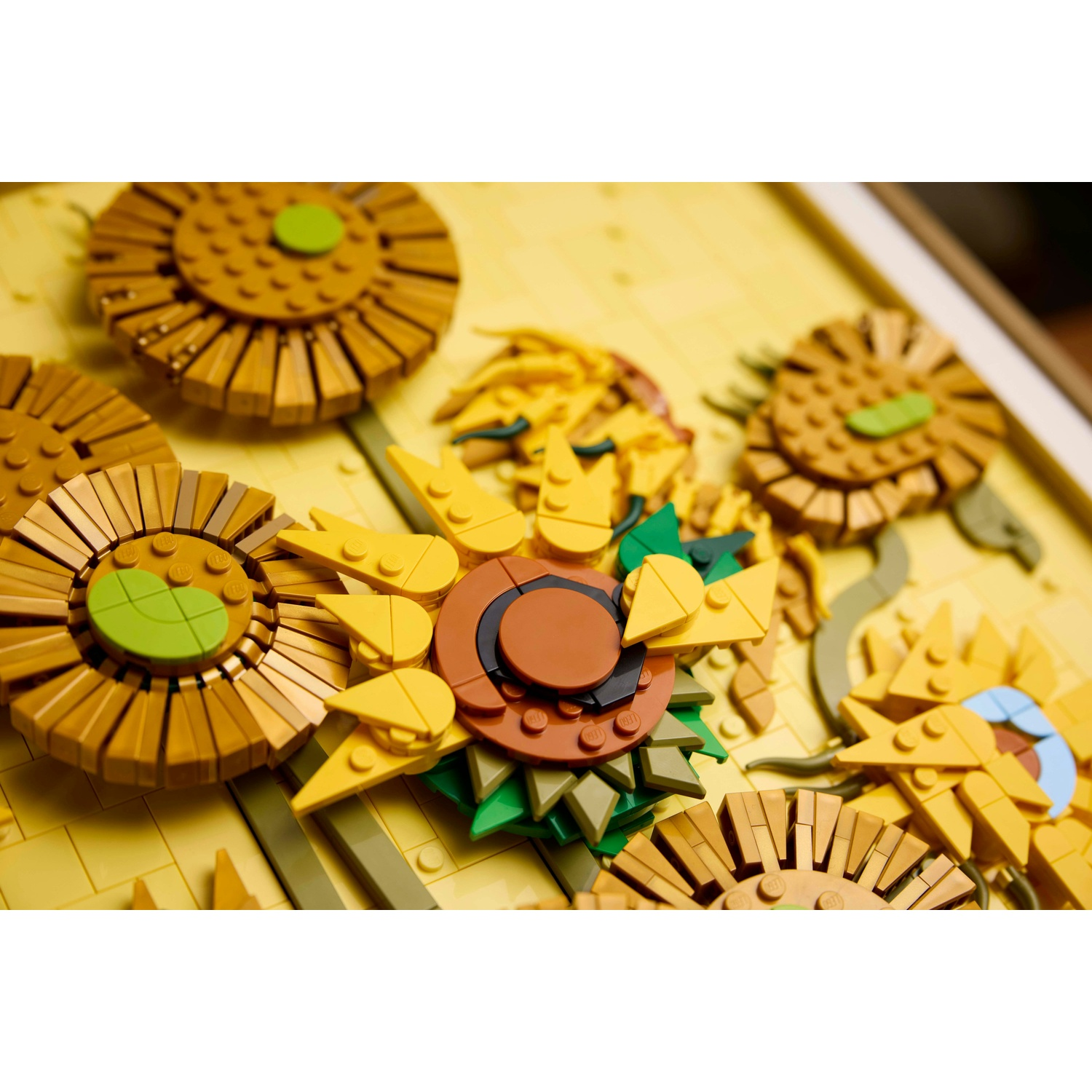 Primo piano di un mosaico di girasole Lego con petali gialli e centri marroni.