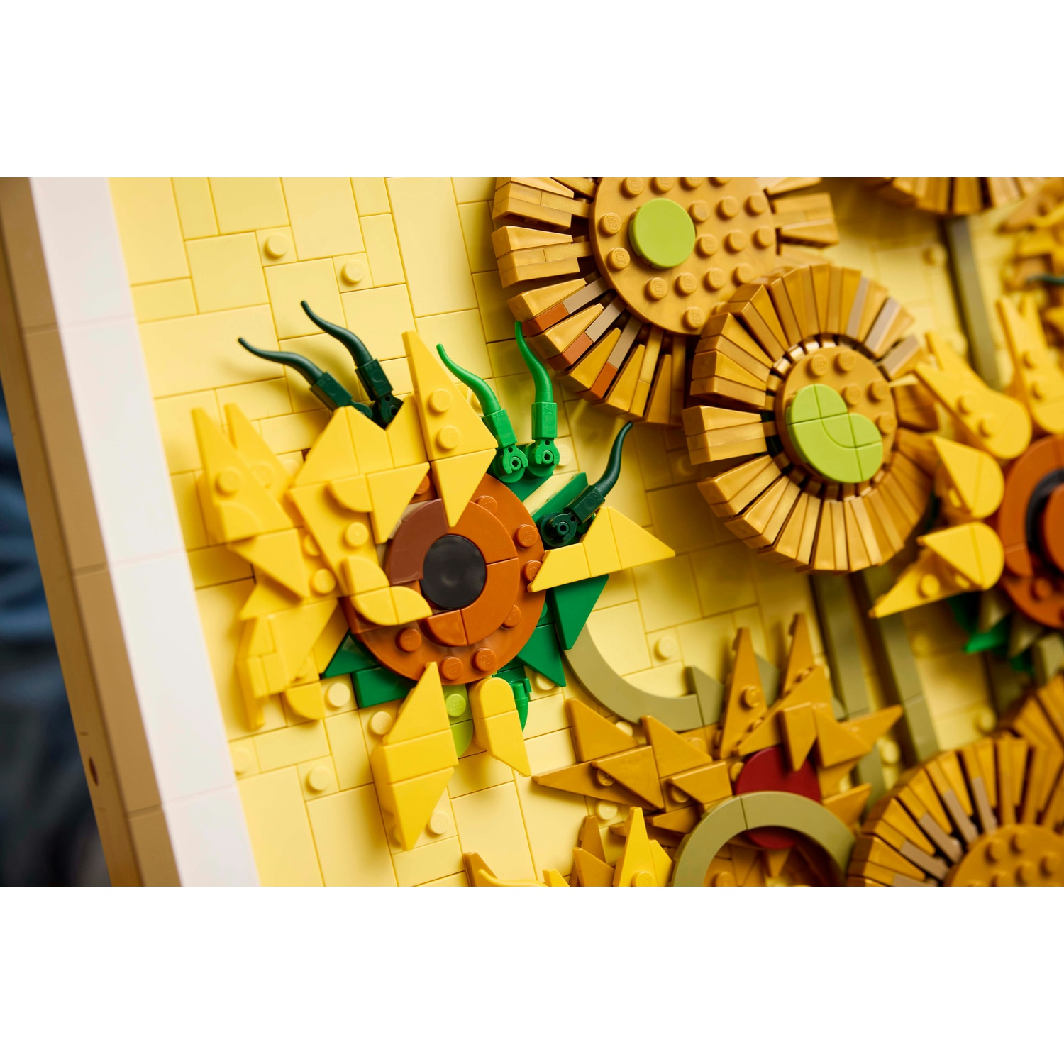 Un mosaico LEGO di girasoli in giallo, arancione e verde, con centri marroni.