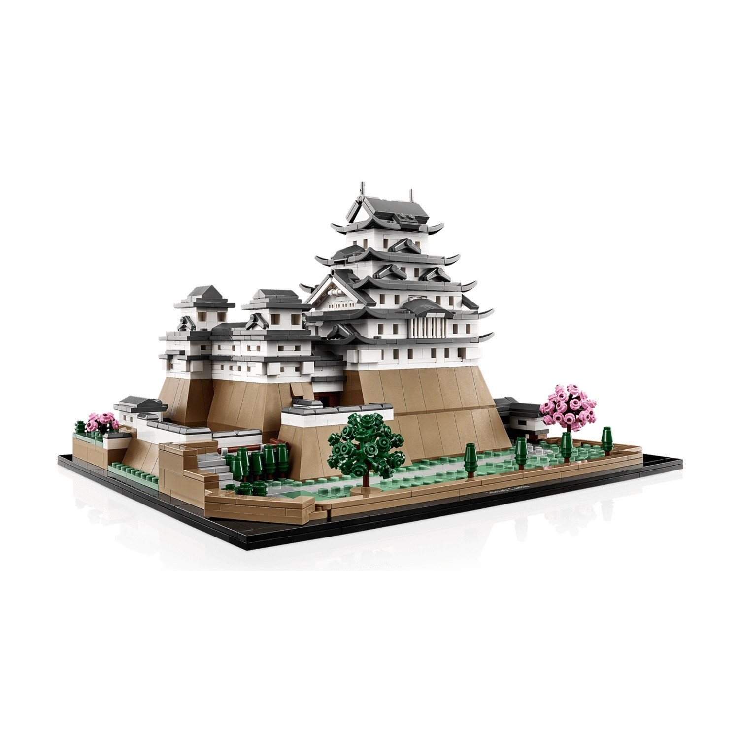 Un modello Lego di un castello con torri bianche e marroni, alberi e fiori rosa.