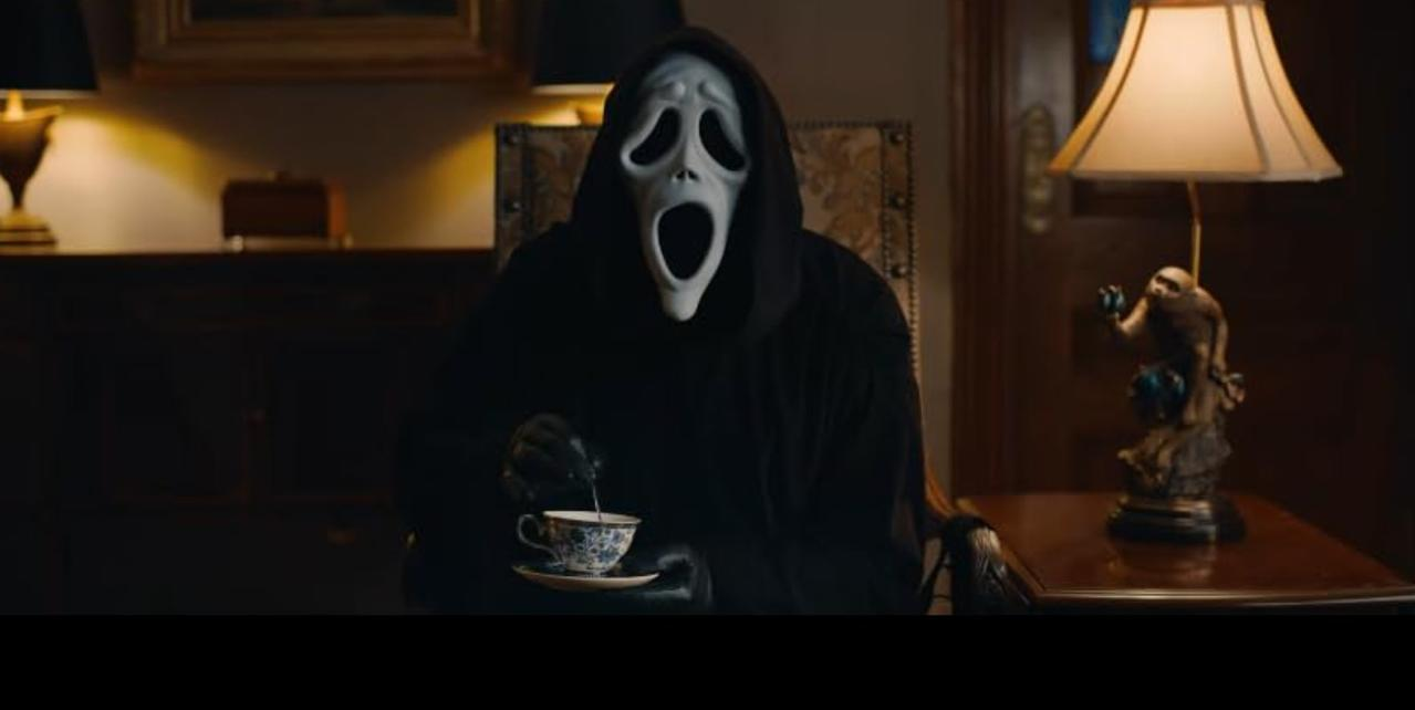 Geist-Masken-Figur gießt Tee in ein Tassen-Set in einem dunklen Raum.