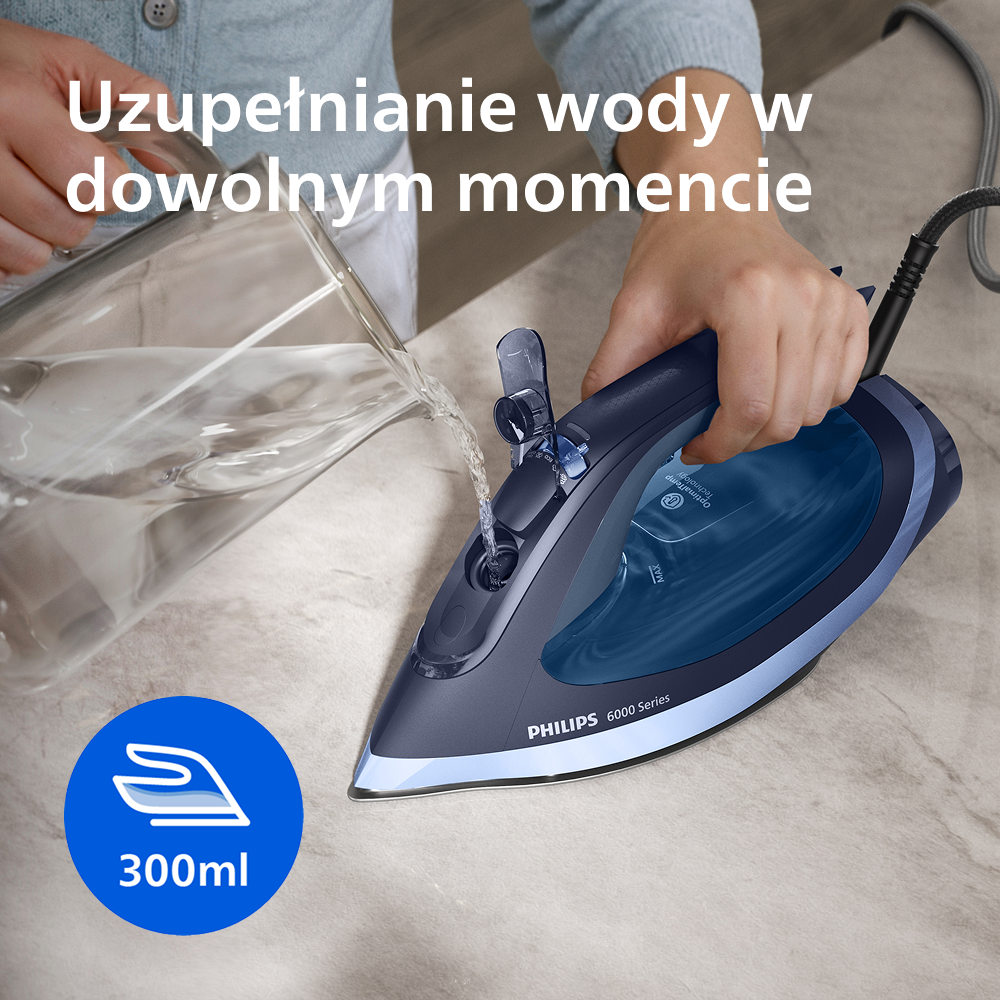 Ręka wlewa wodę z dzbanka do niebieskiego żelazka. Pojemność 300 ml.