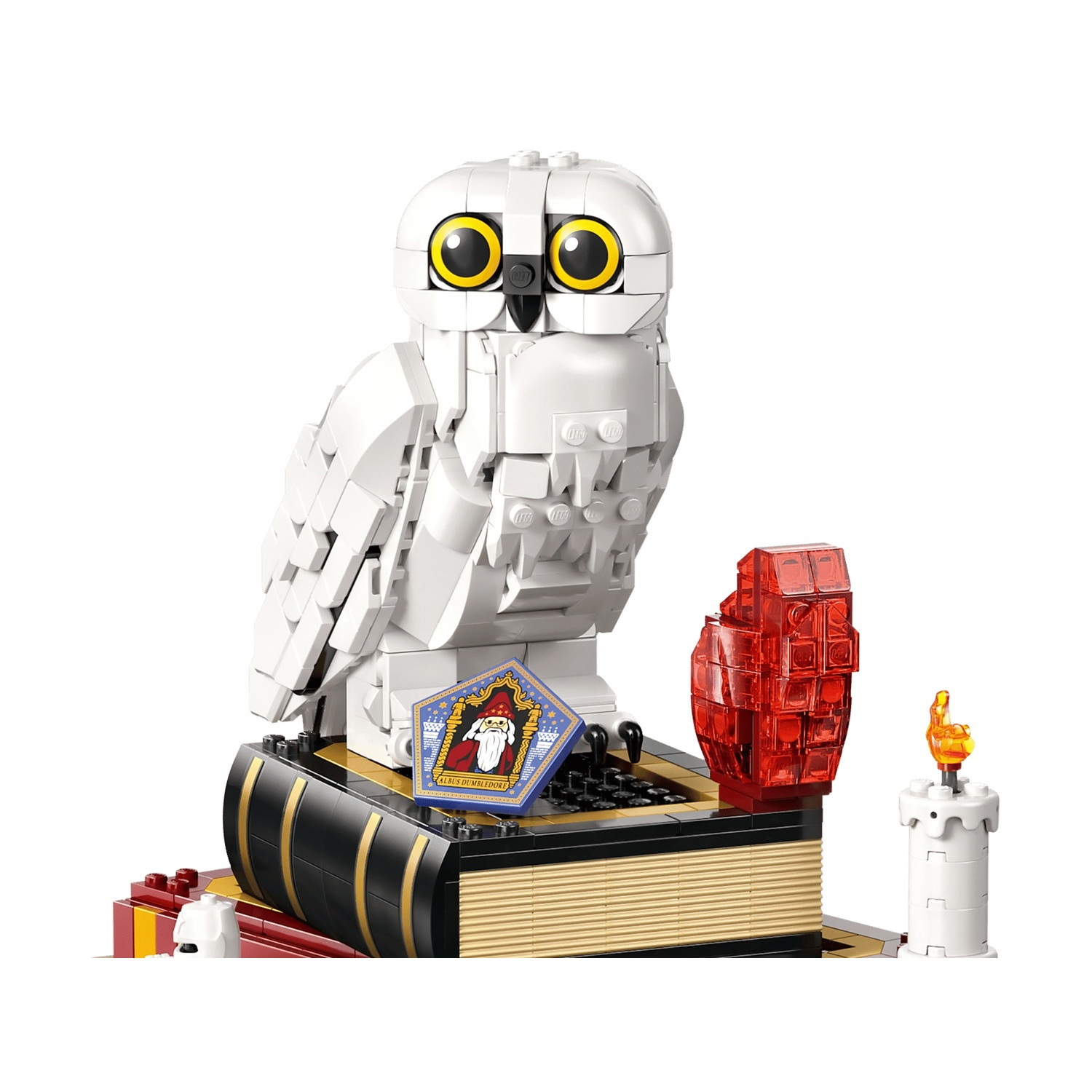Un modello di gufo delle nevi Lego con occhi giallo brillante siede su un libro.