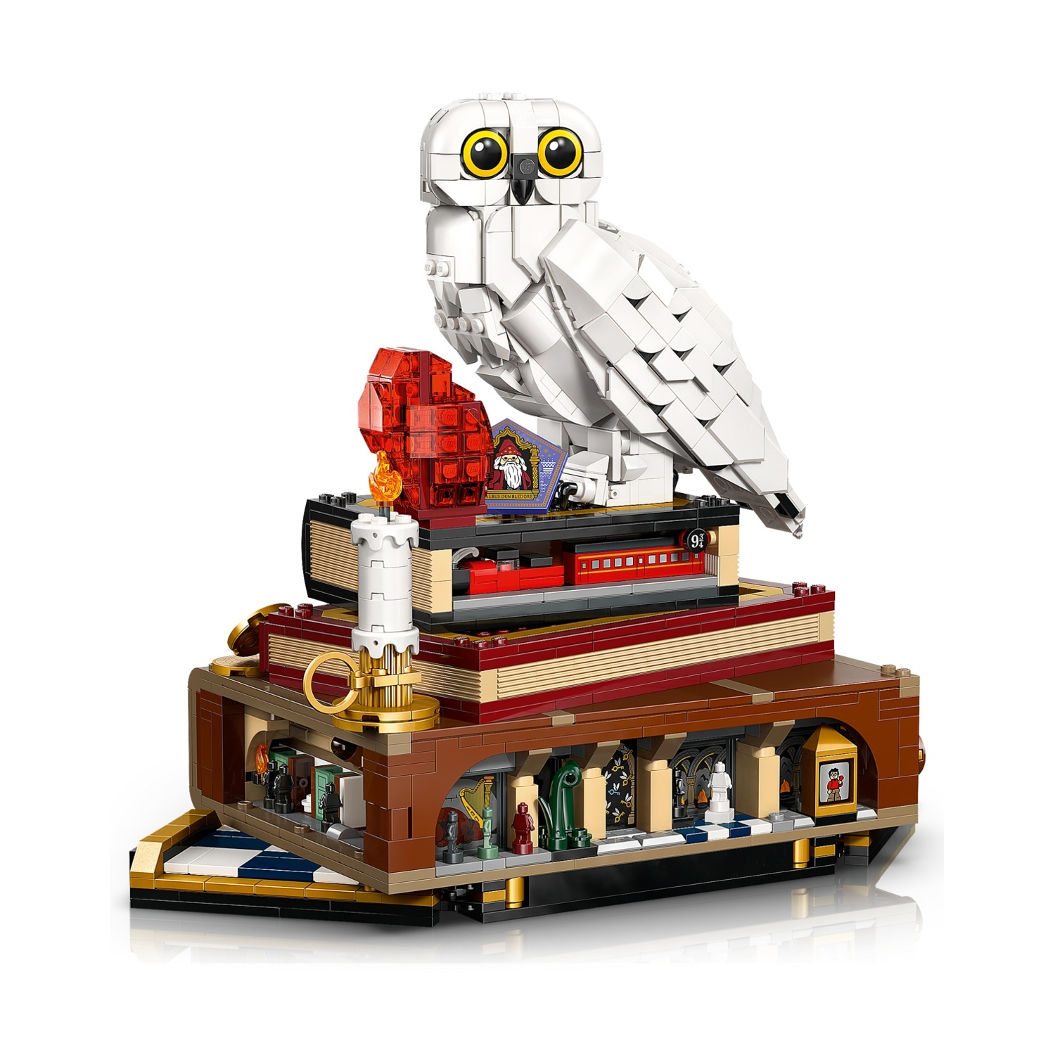 Modellino Lego di un gufo bianco su una pila di libri, con treno e candela.