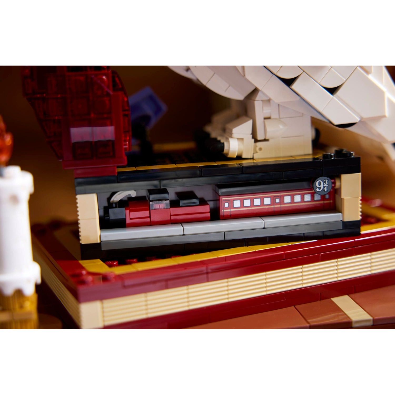 Modello Lego di un treno con carrozze e il numero 9 3/4 su una base di libro.