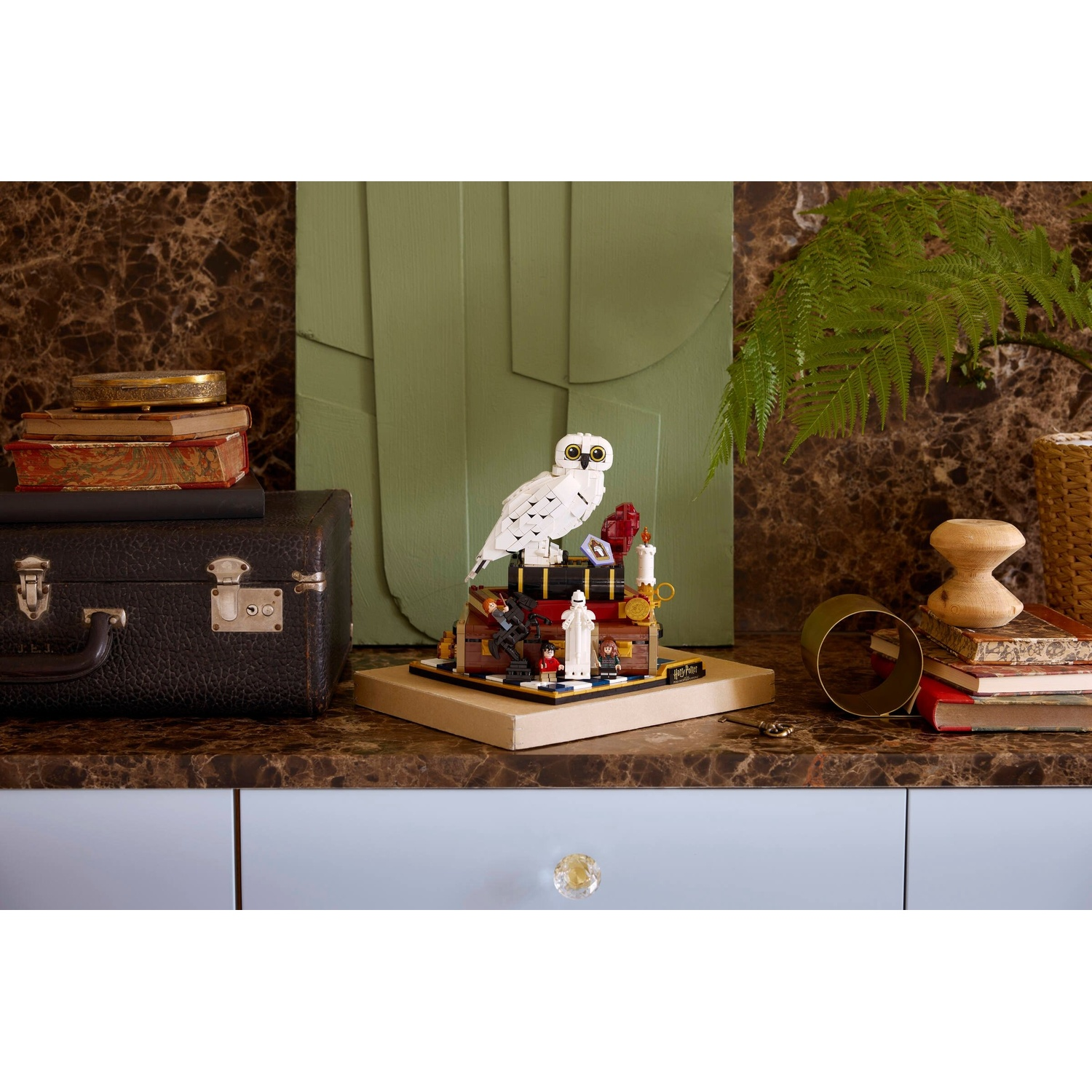 Un set Lego Harry Potter con gufo, figure e libri su un bancone di marmo.