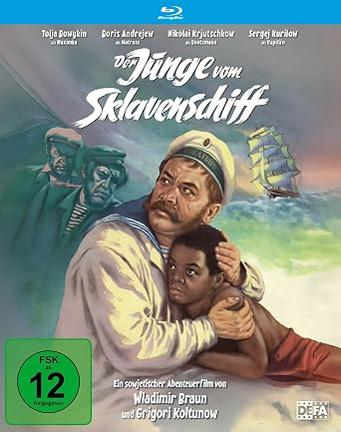 Ein Mann in Matrosenuniform hält einen Jungen. Ein Segelschiff segelt im Hintergrund.