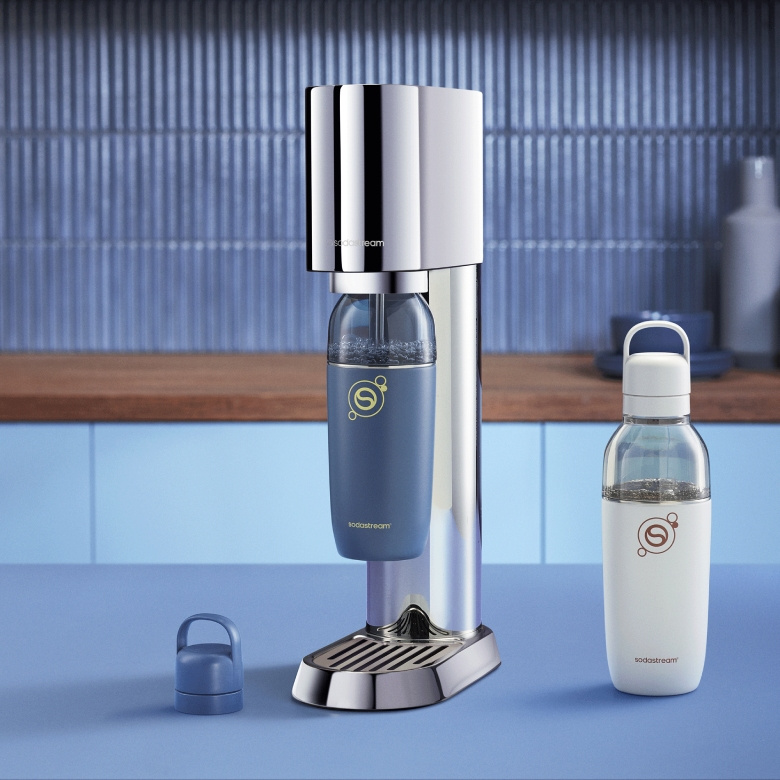 Srebrny ekspres SodaStream z niebieską butelką i białą butelką obok.