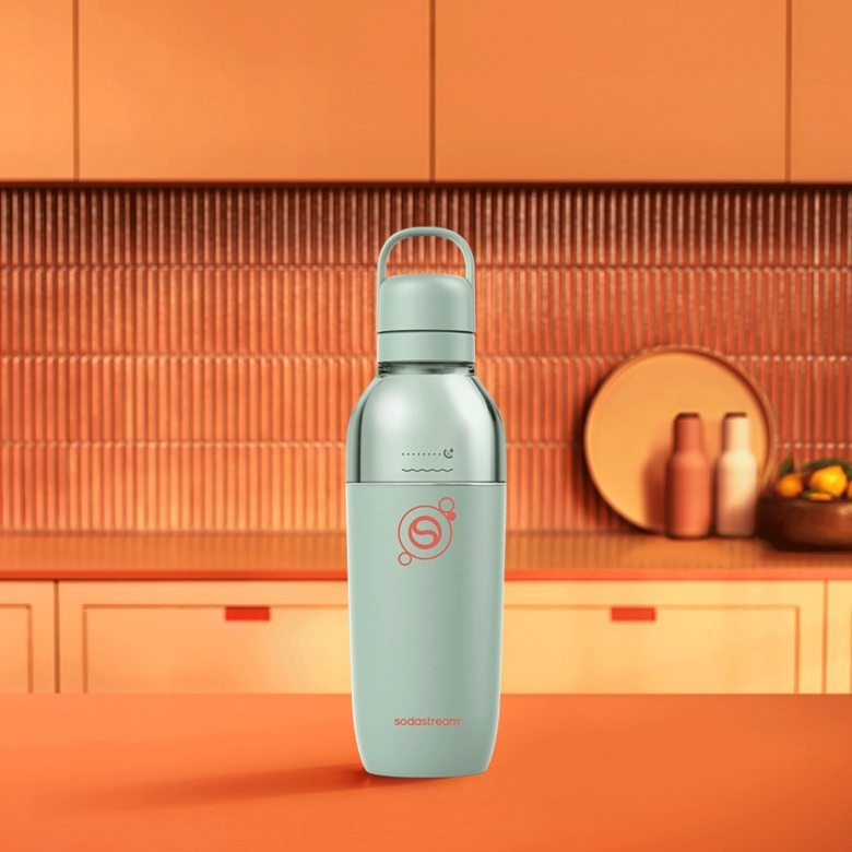 Jasnozielona butelka SodaStream z białym uchwytem na pomarańczowej powierzchni.
