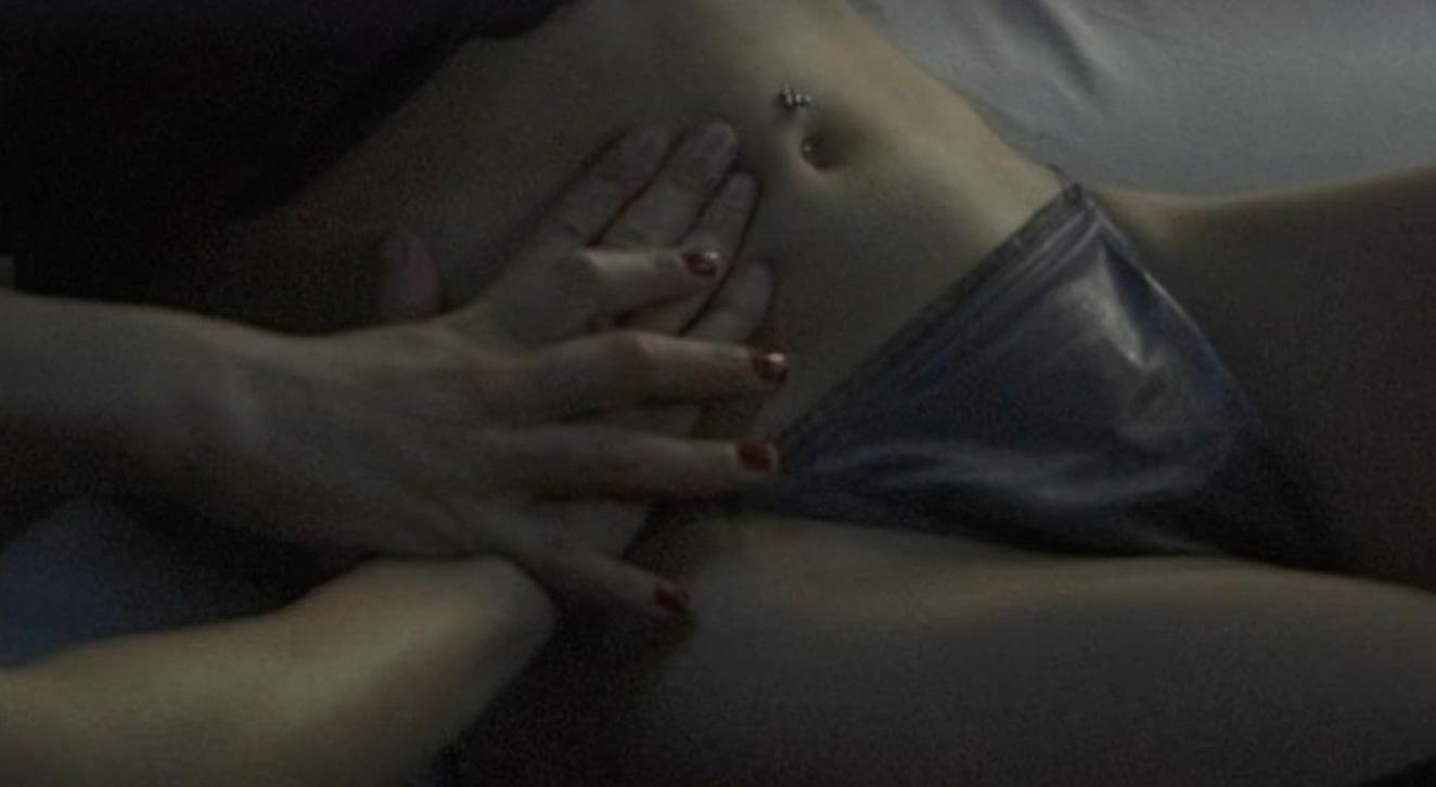 Hände auf Bauch und Hüfte einer Person mit Bauchnabelpiercing.