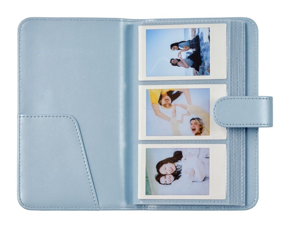 Jasnoniebieski album z trzema zdjęciami polaroid młodych kobiet. Posiada magnetyczne zapięcie.