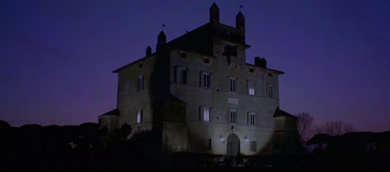 Ein hell erleuchtetes Schloss mit Türmchen vor einem dunklen Nachthimmel.