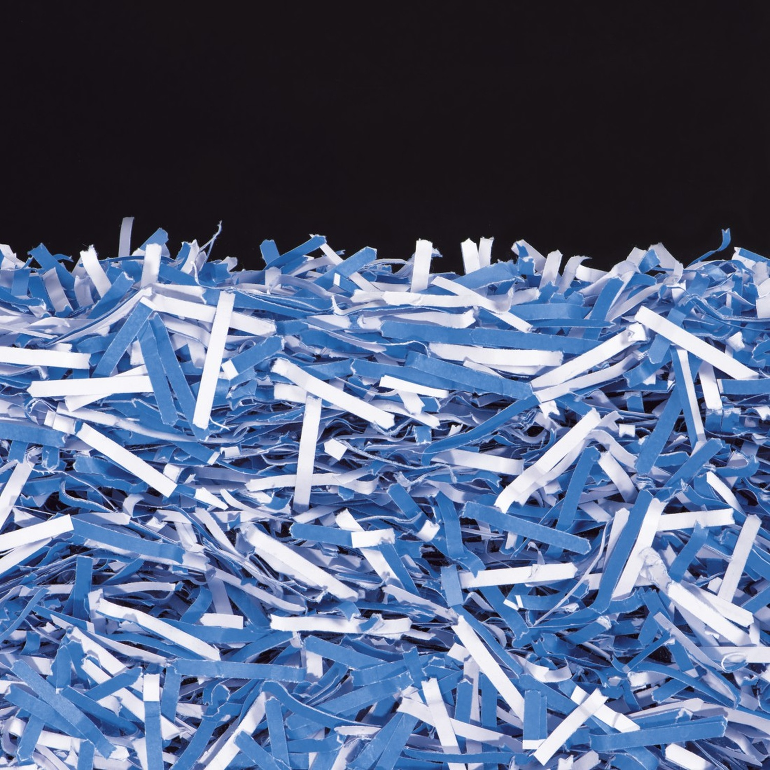 Een hoopje blauw en wit papier snippers tegen een zwarte achtergrond.