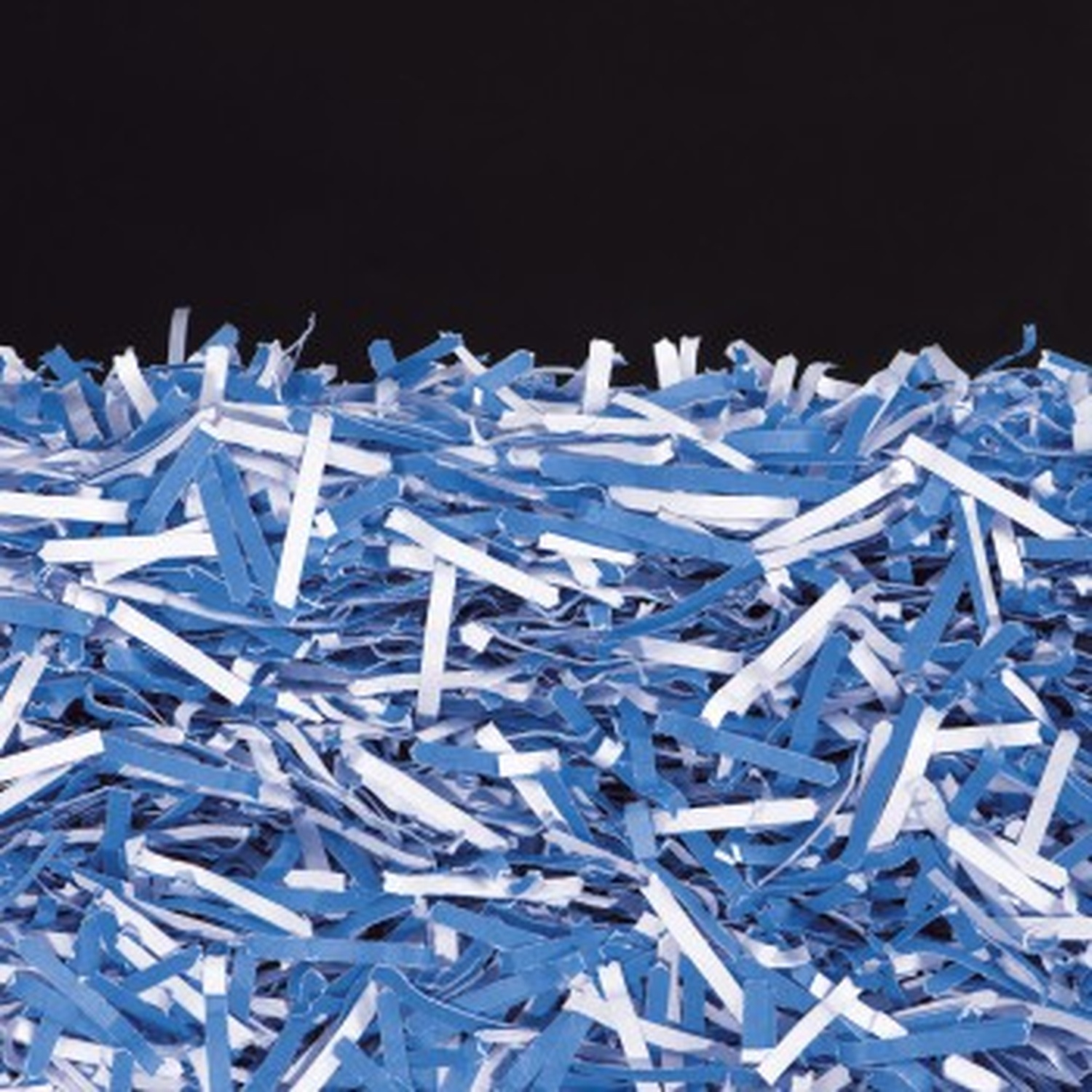 Blauw en wit versnipperd papier tegen een zwarte achtergrond.