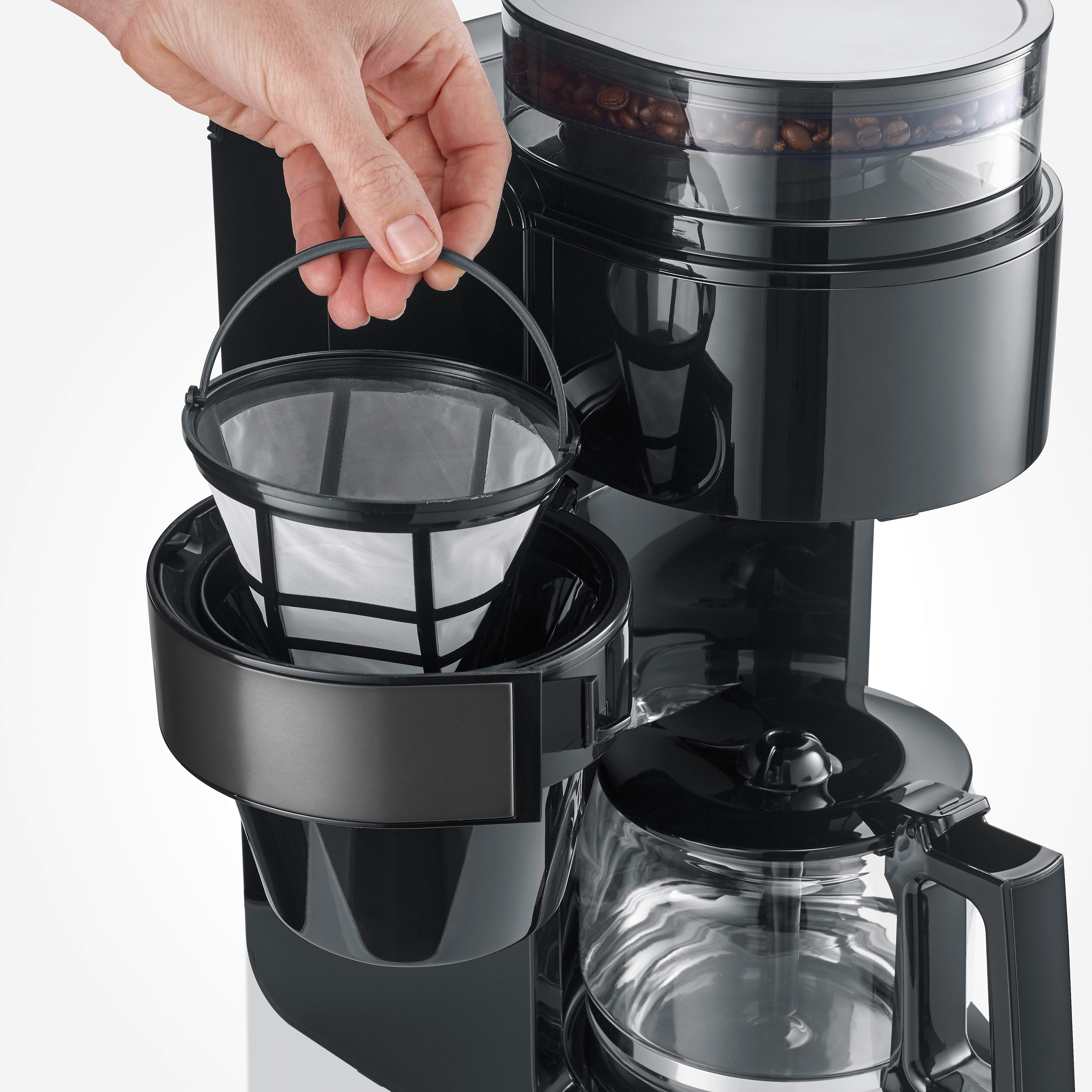 Eine Hand setzt einen Kaffeefilter in eine Kaffeemaschine ein.