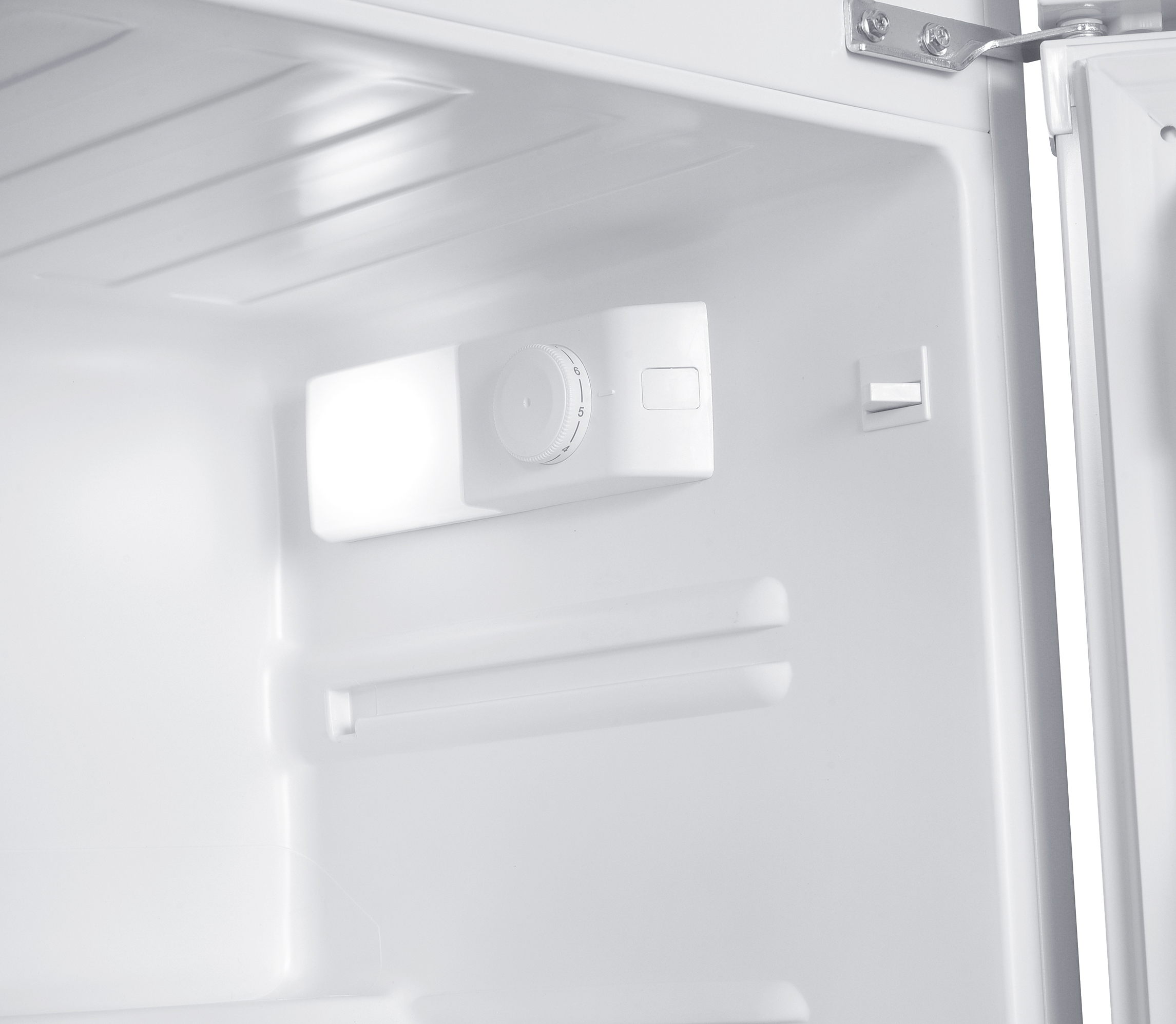Interior de un refrigerador blanco con control de temperatura y bisagra.