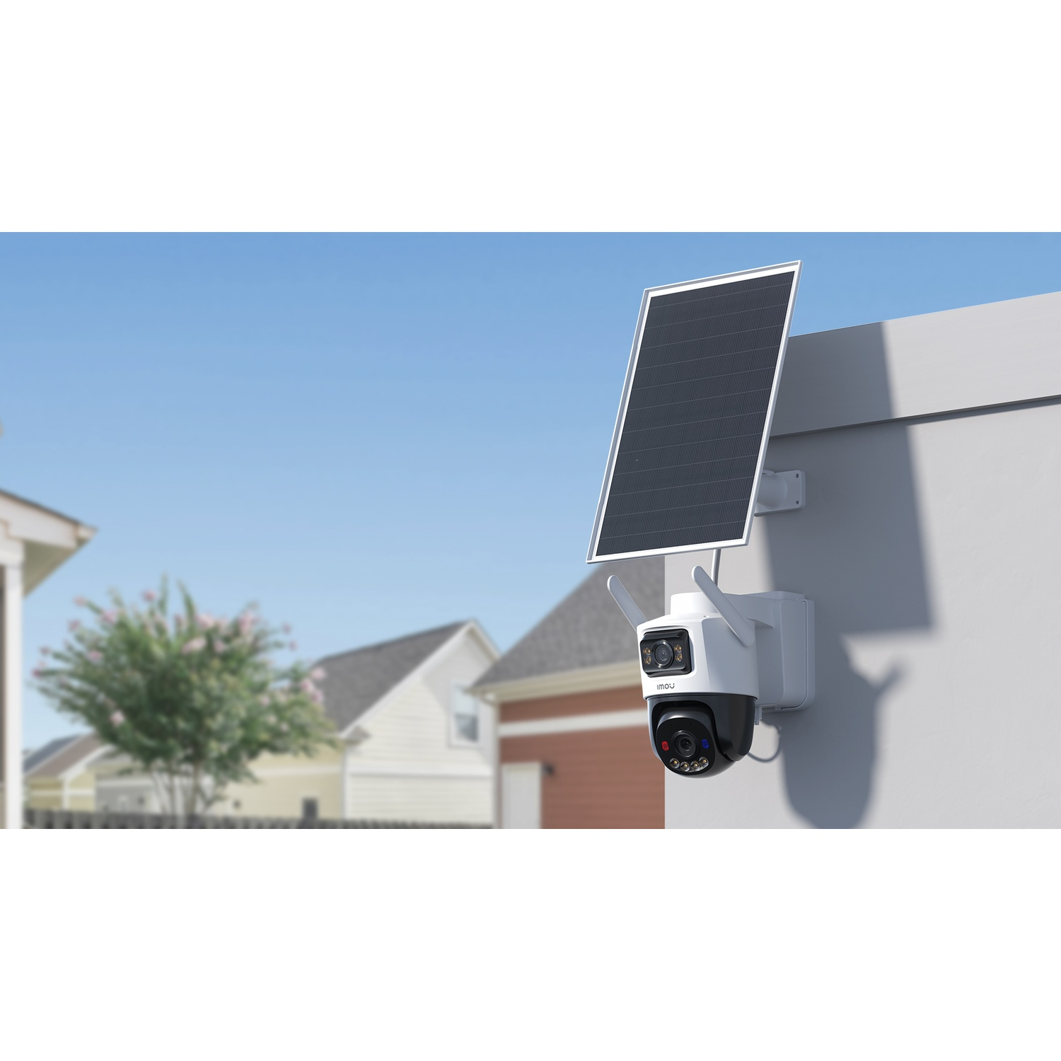 Une caméra de sécurité blanche avec panneau solaire est montée sur un mur. Maisons et arbres à l'arrière-plan.