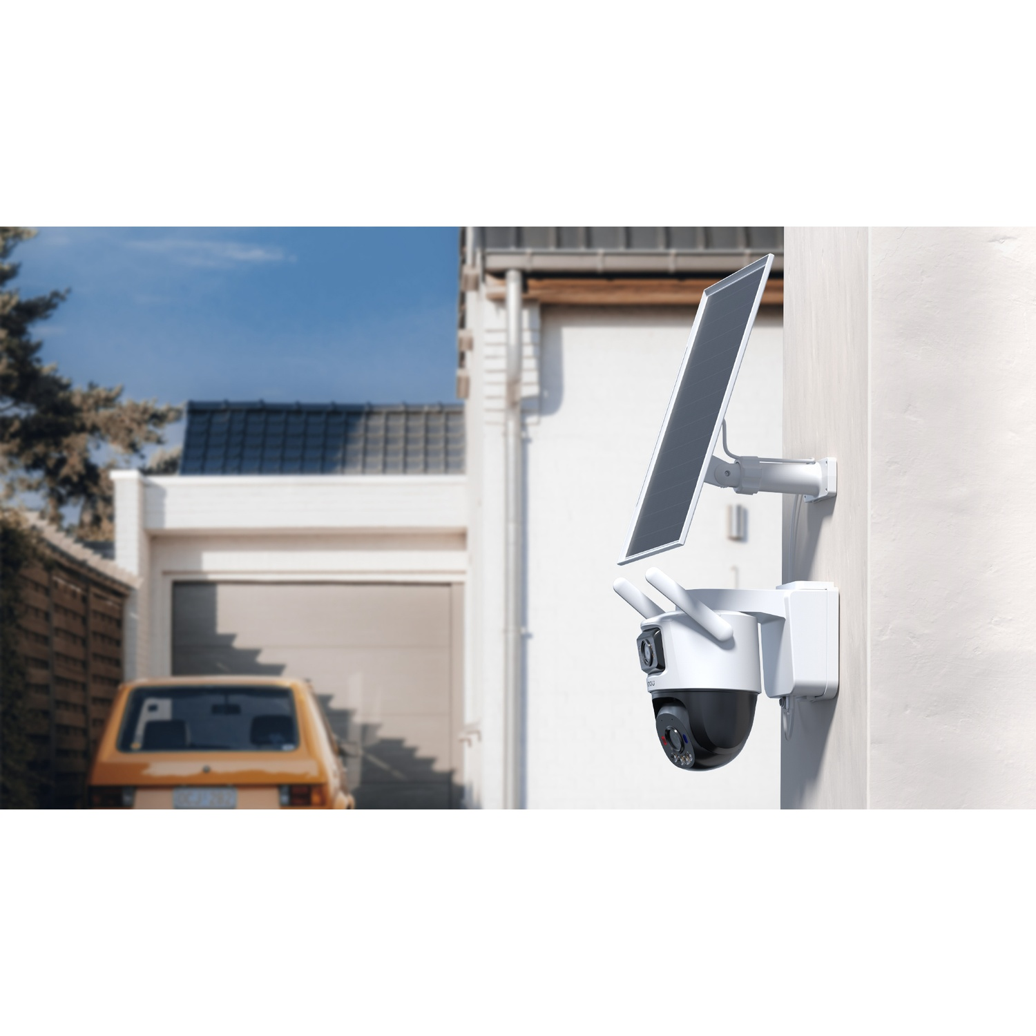Une caméra de sécurité blanche alimentée par énergie solaire avec panneau solaire est montée sur un mur, avec un garage et une voiture en arrière-plan.