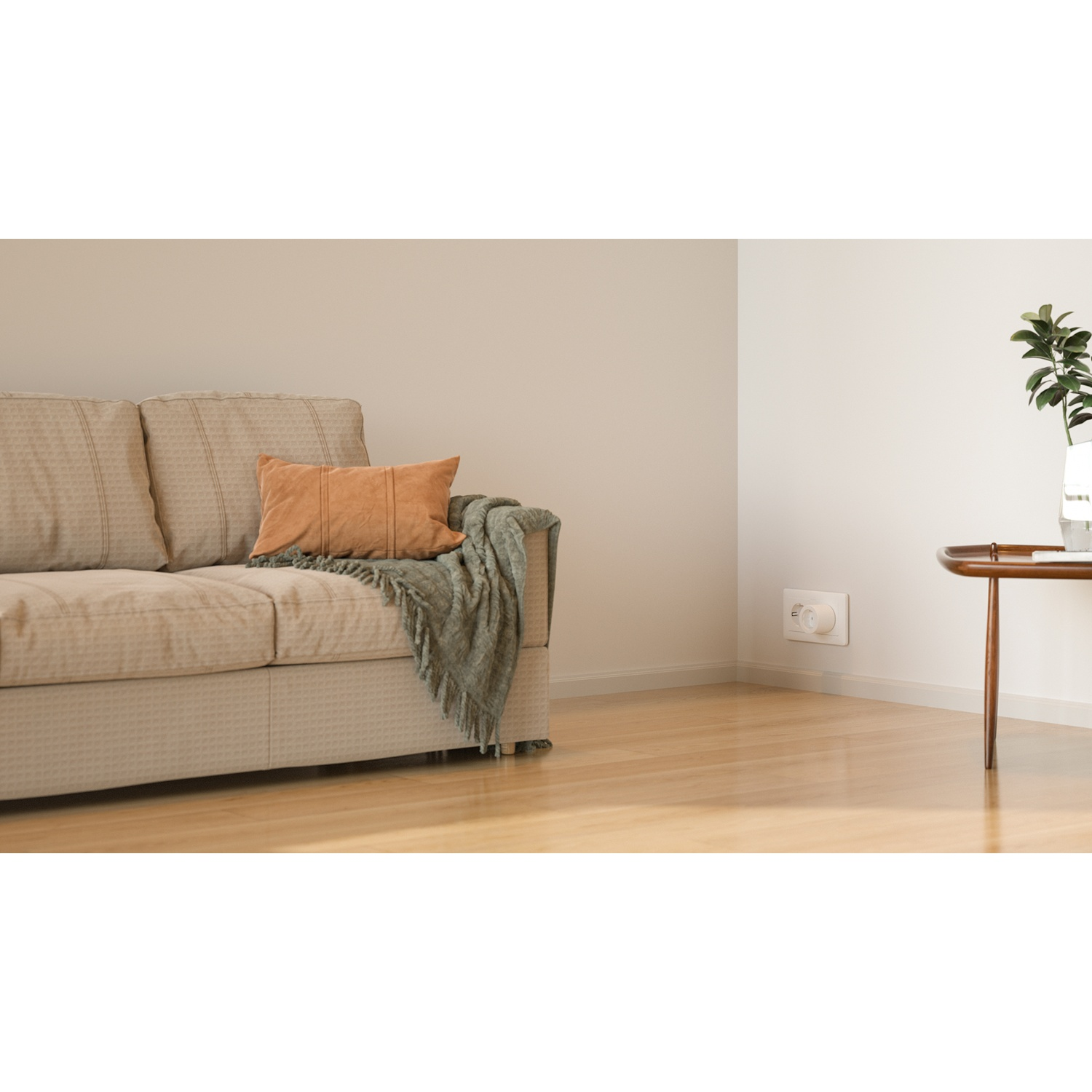 Een beige bank met bruin kussen en groene deken op houten vloer.