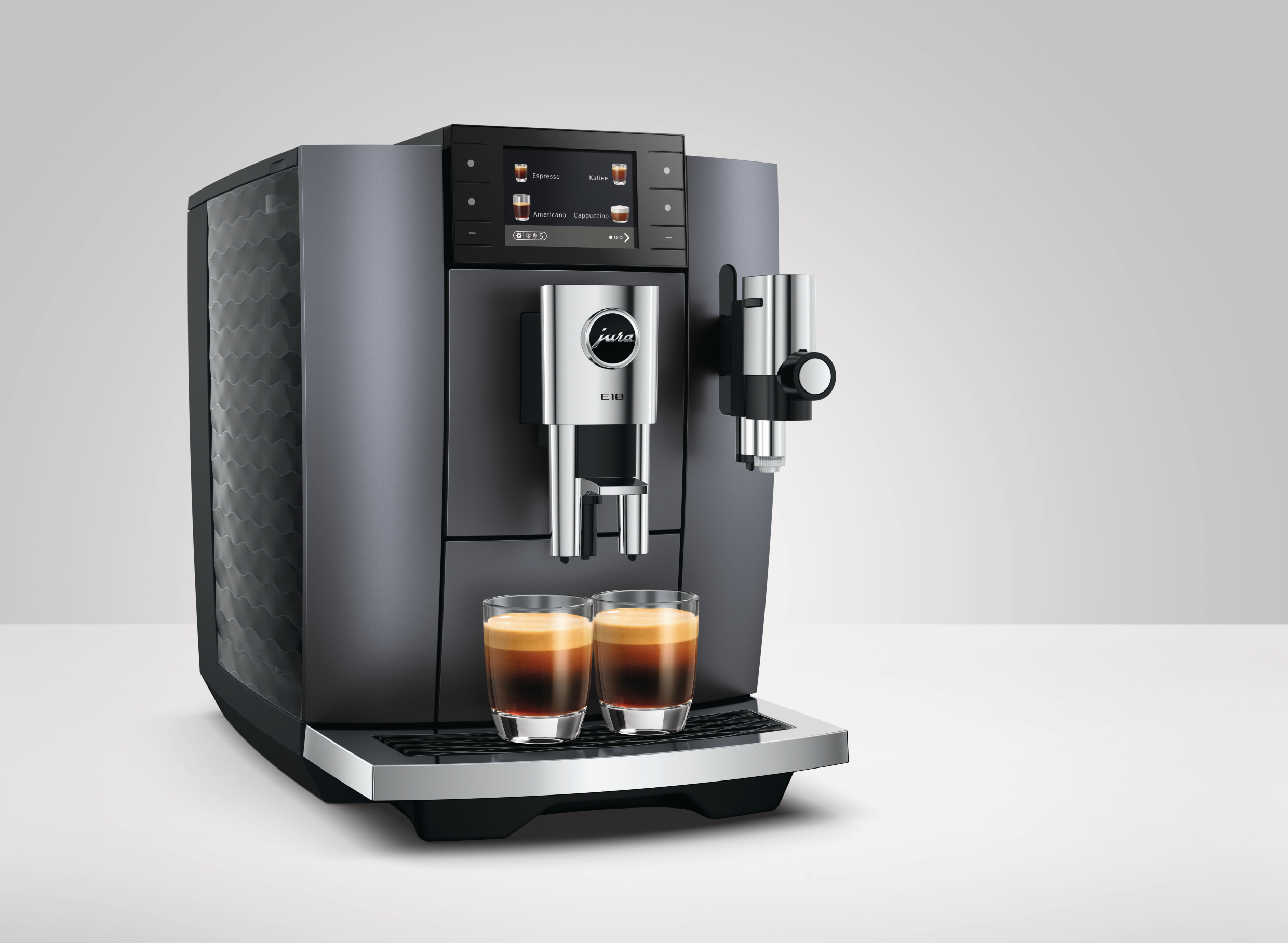 Moderne Jura Kaffeemaschine mit zwei Gläsern Espresso und Touchscreen-Display.