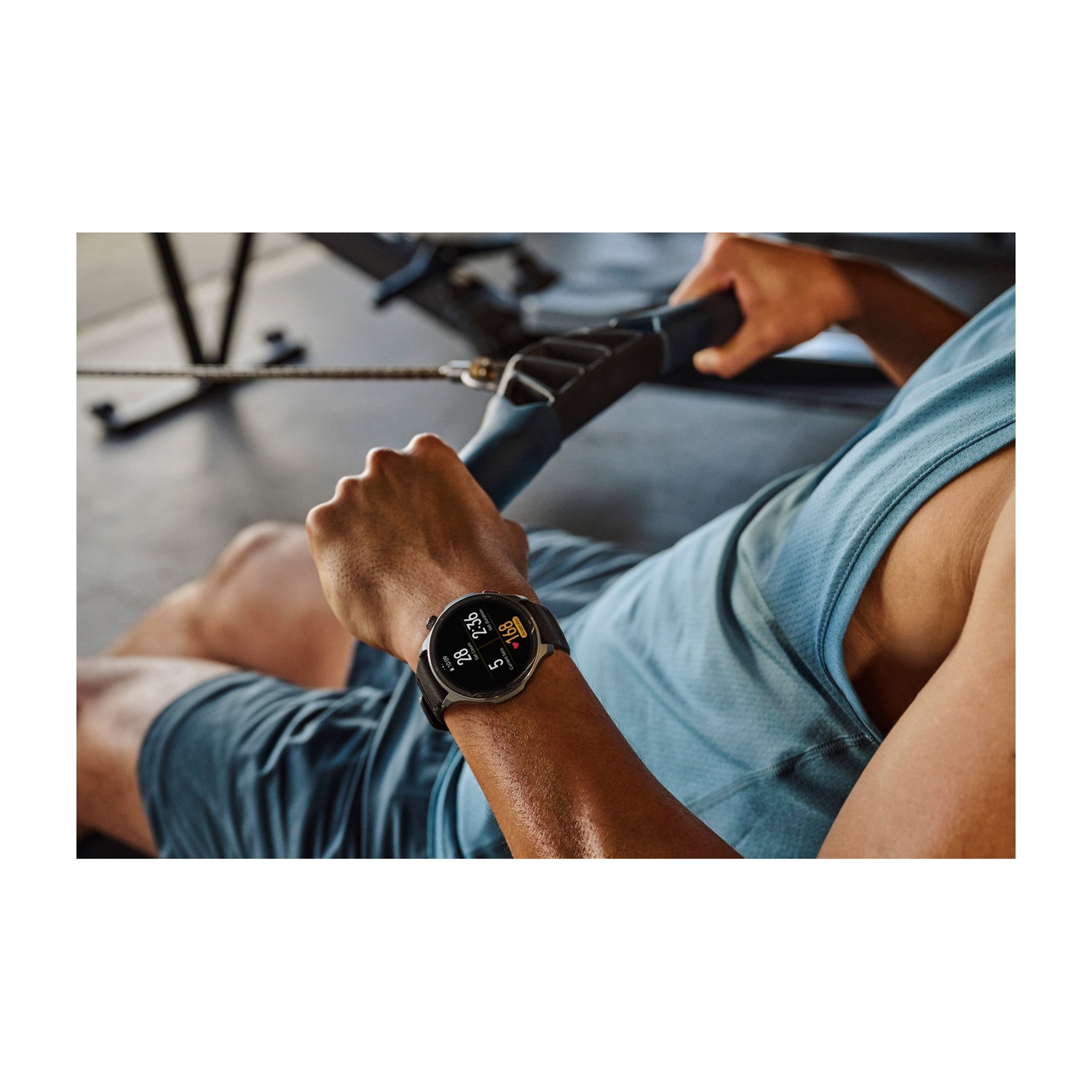 Uomo con smartwatch si allena su vogatore in palestra.