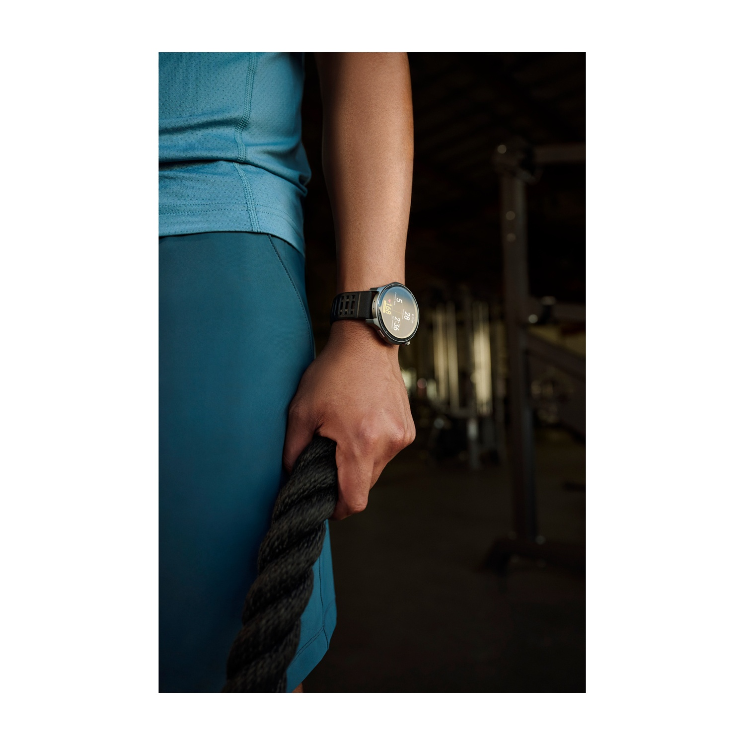 Una persona in abbigliamento sportivo tiene una fune spessa. Un orologio intelligente è visibile sul polso.