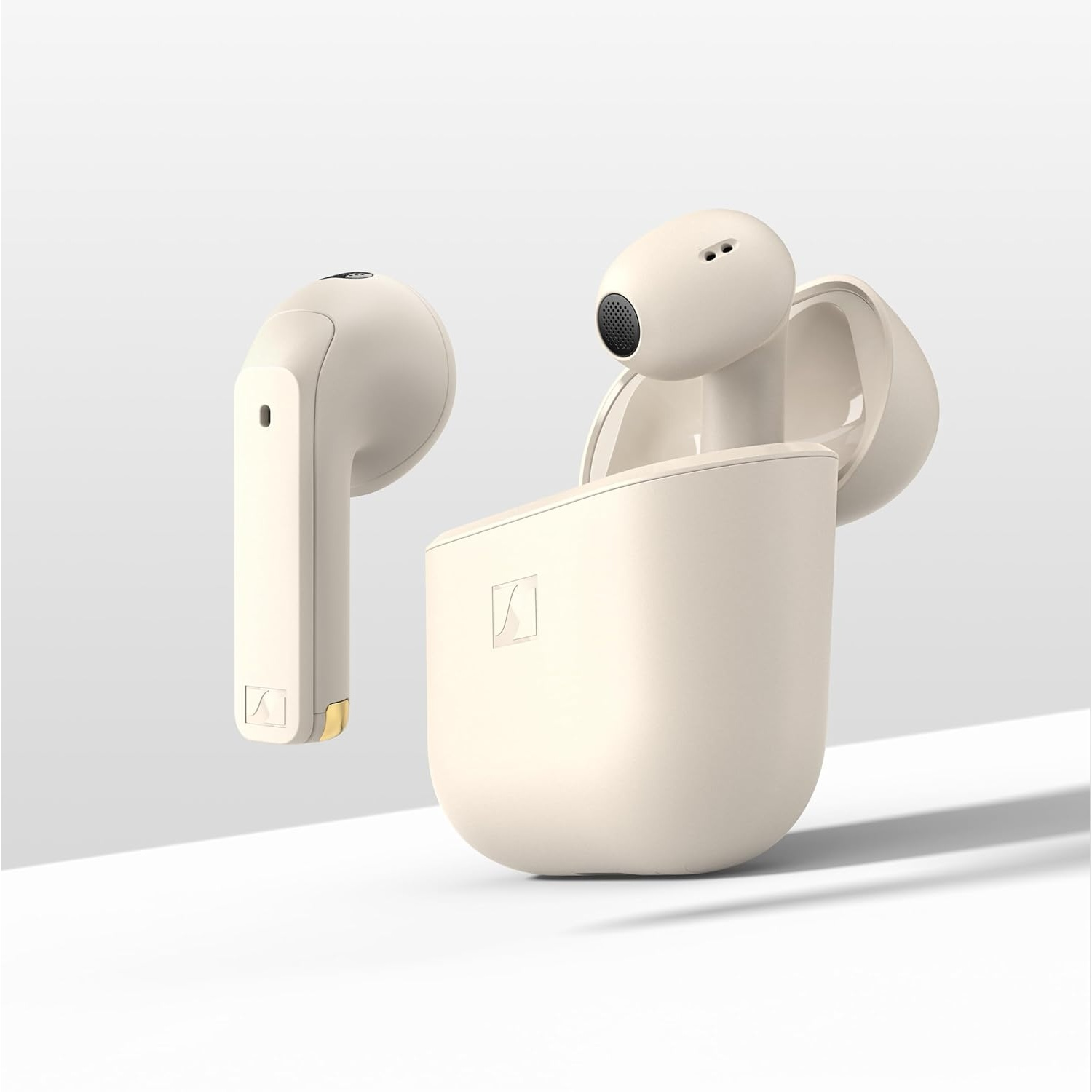 Due auricolari wireless color crema, uno in una custodia di ricarica aperta.