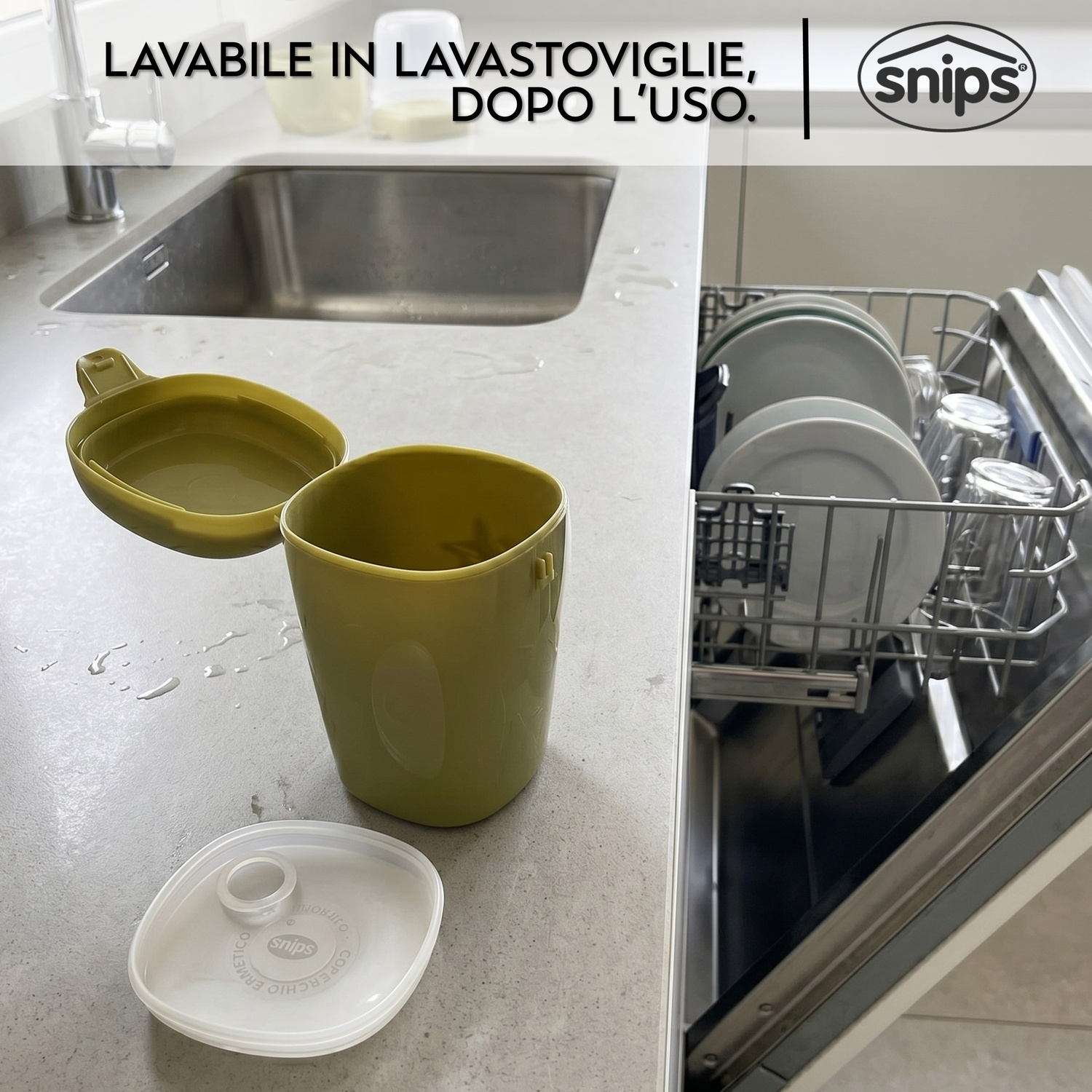 Tazza e coperchio verdi sul bancone accanto alla lavastoviglie aperta con piatti.