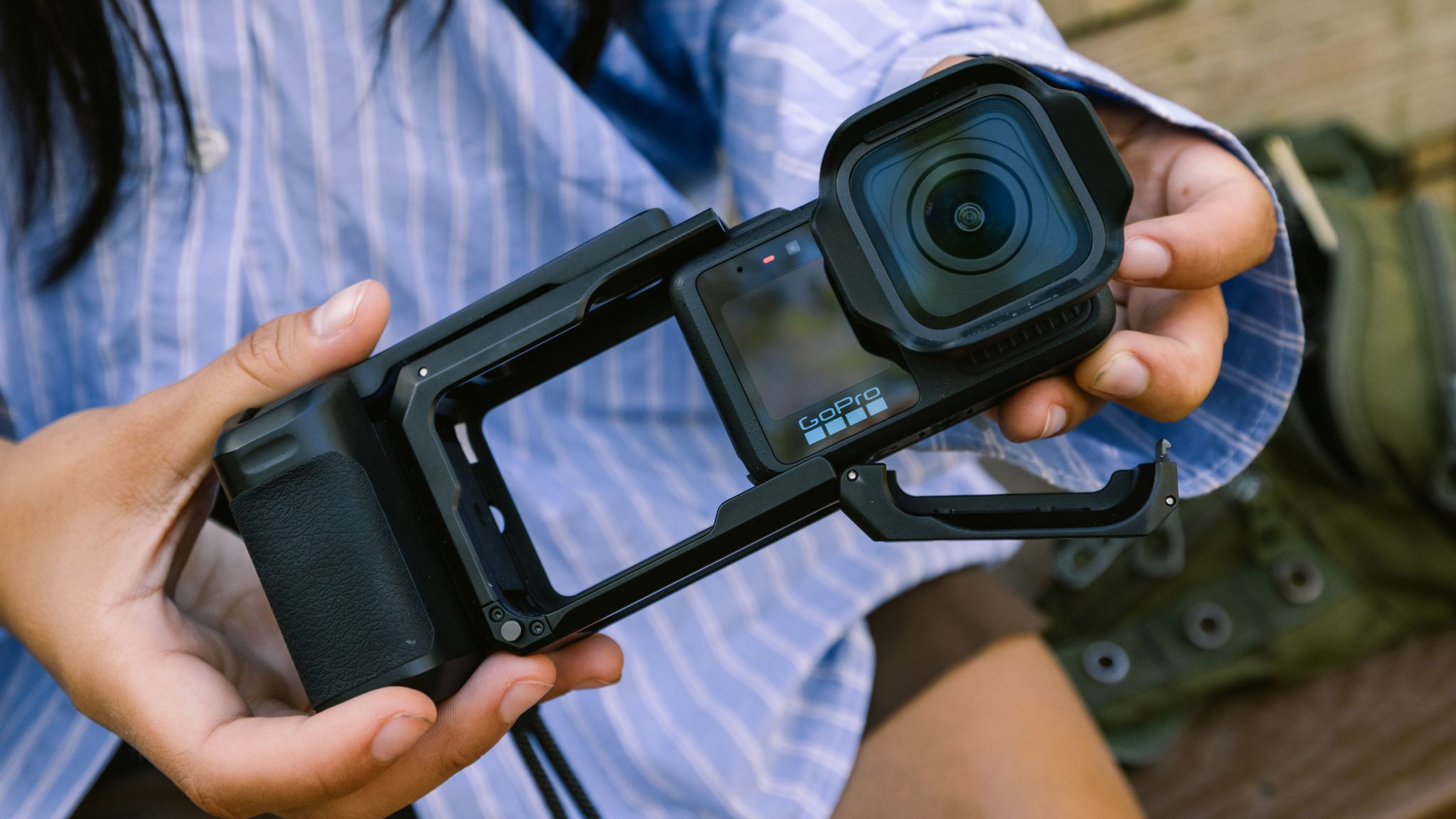 Egy személy GoPro kamerát tart fekete keretben.