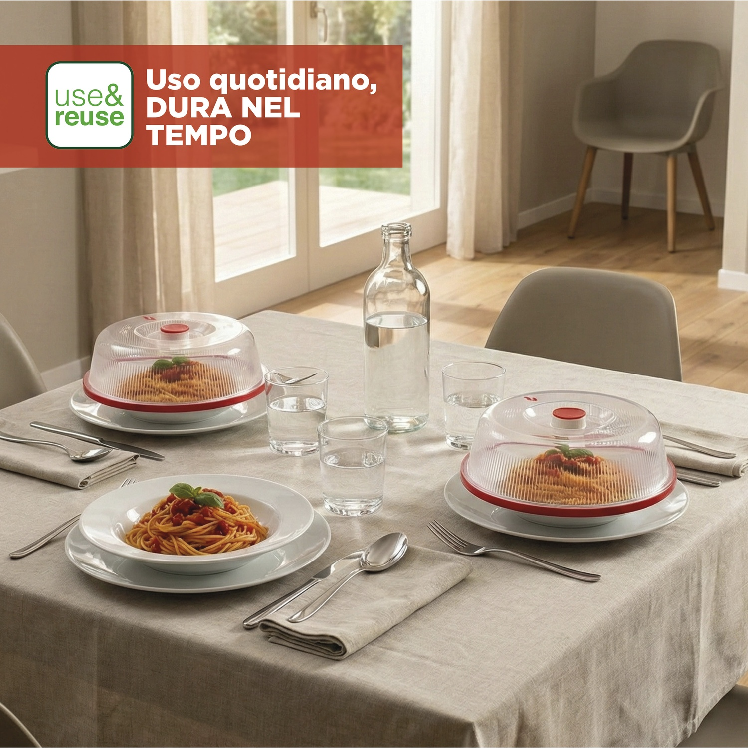 Una tavola apparecchiata con piatti di pasta sotto campane trasparenti, bicchieri e posate.